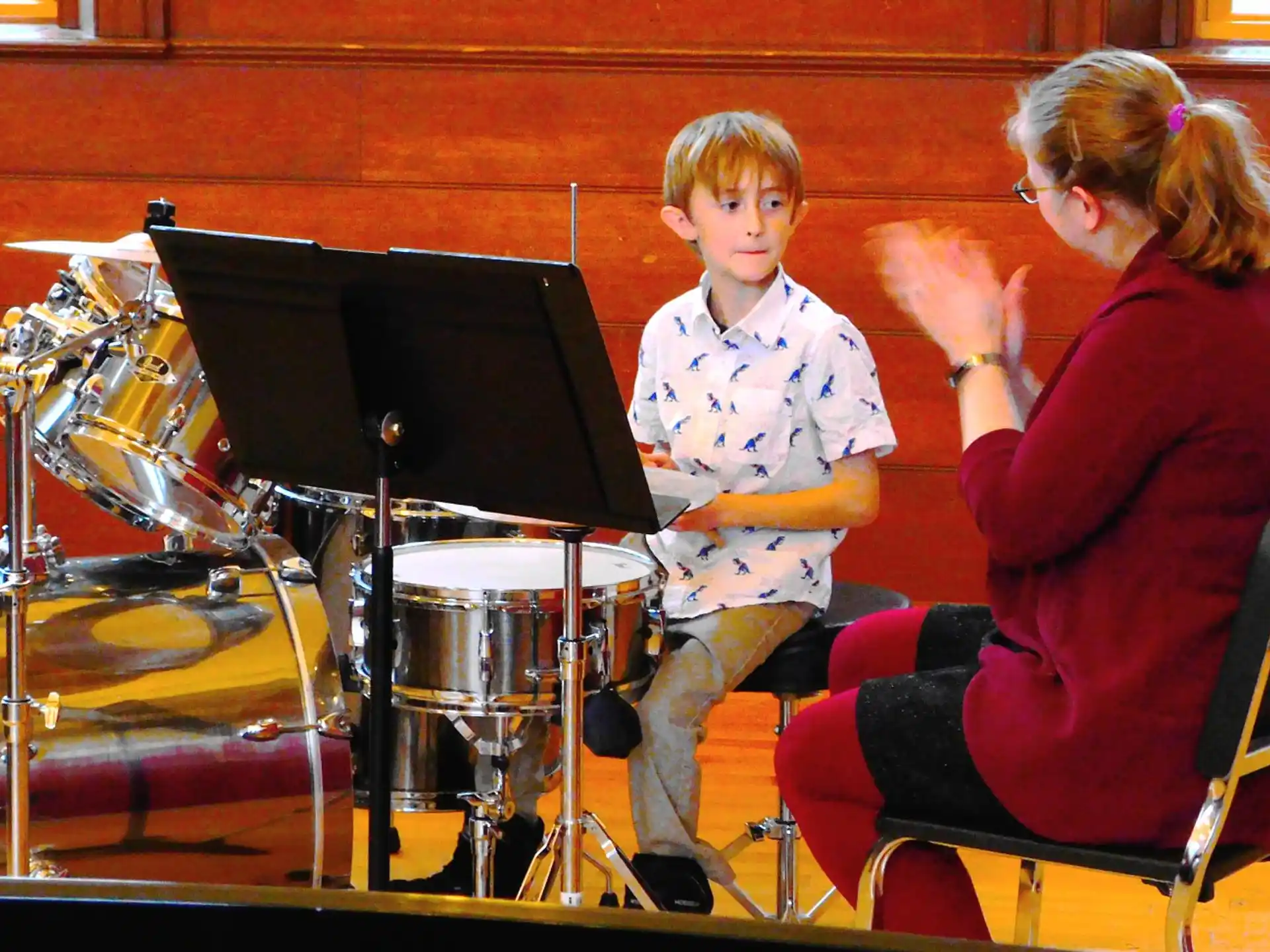 a person and a boy playing drums