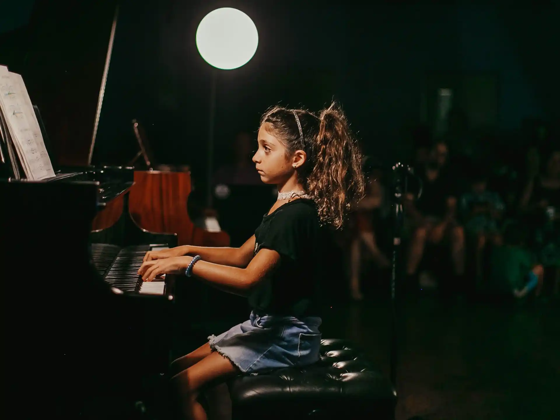 a young girl playing a piano