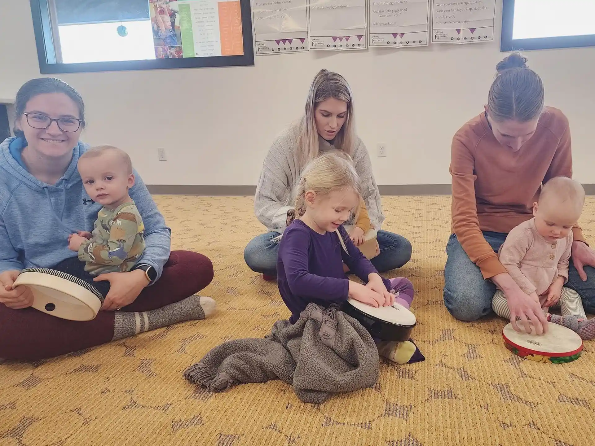 a group of people sitting on the floor with a dog and a cat