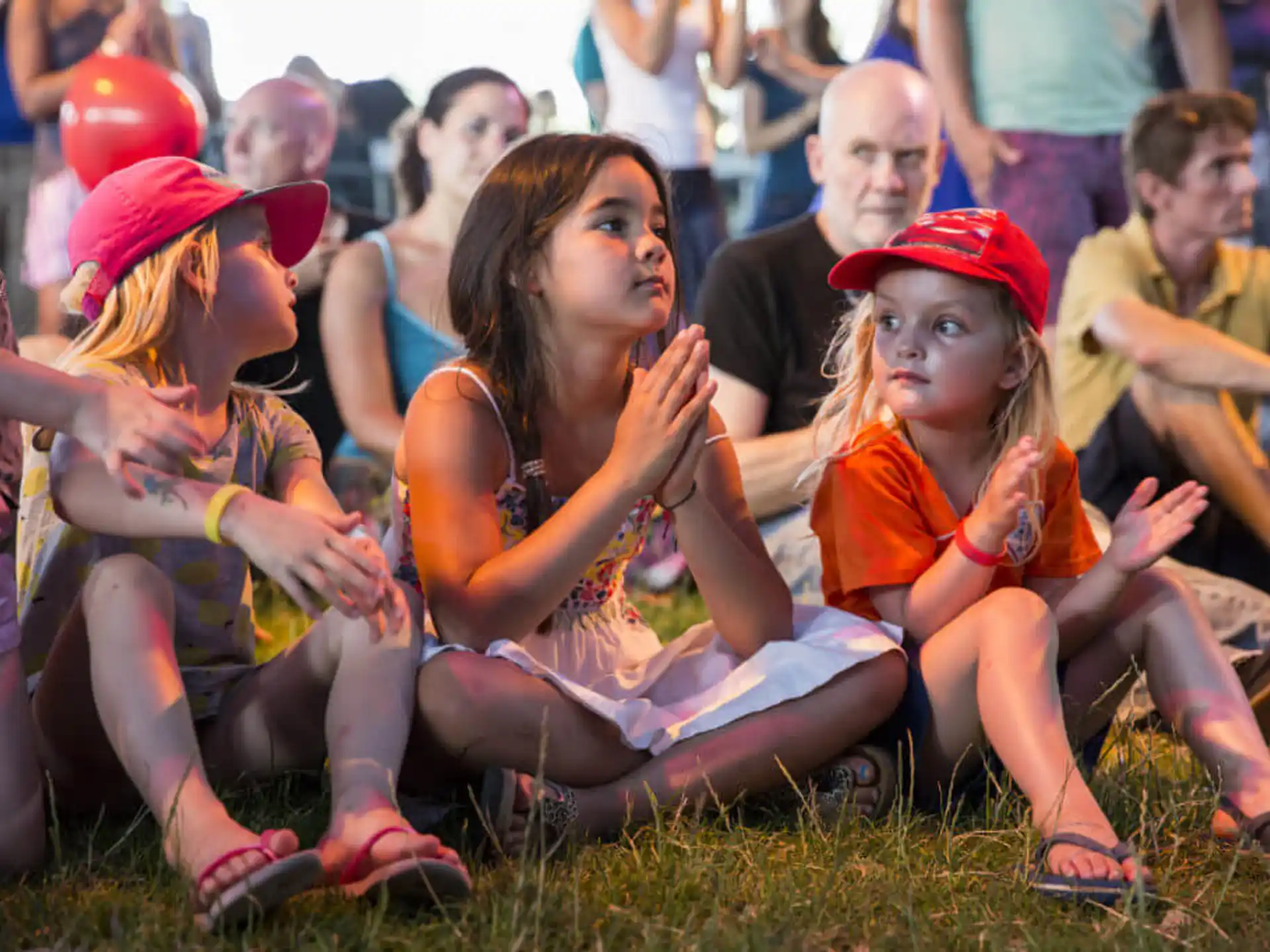 a group of people sitting on the grass
