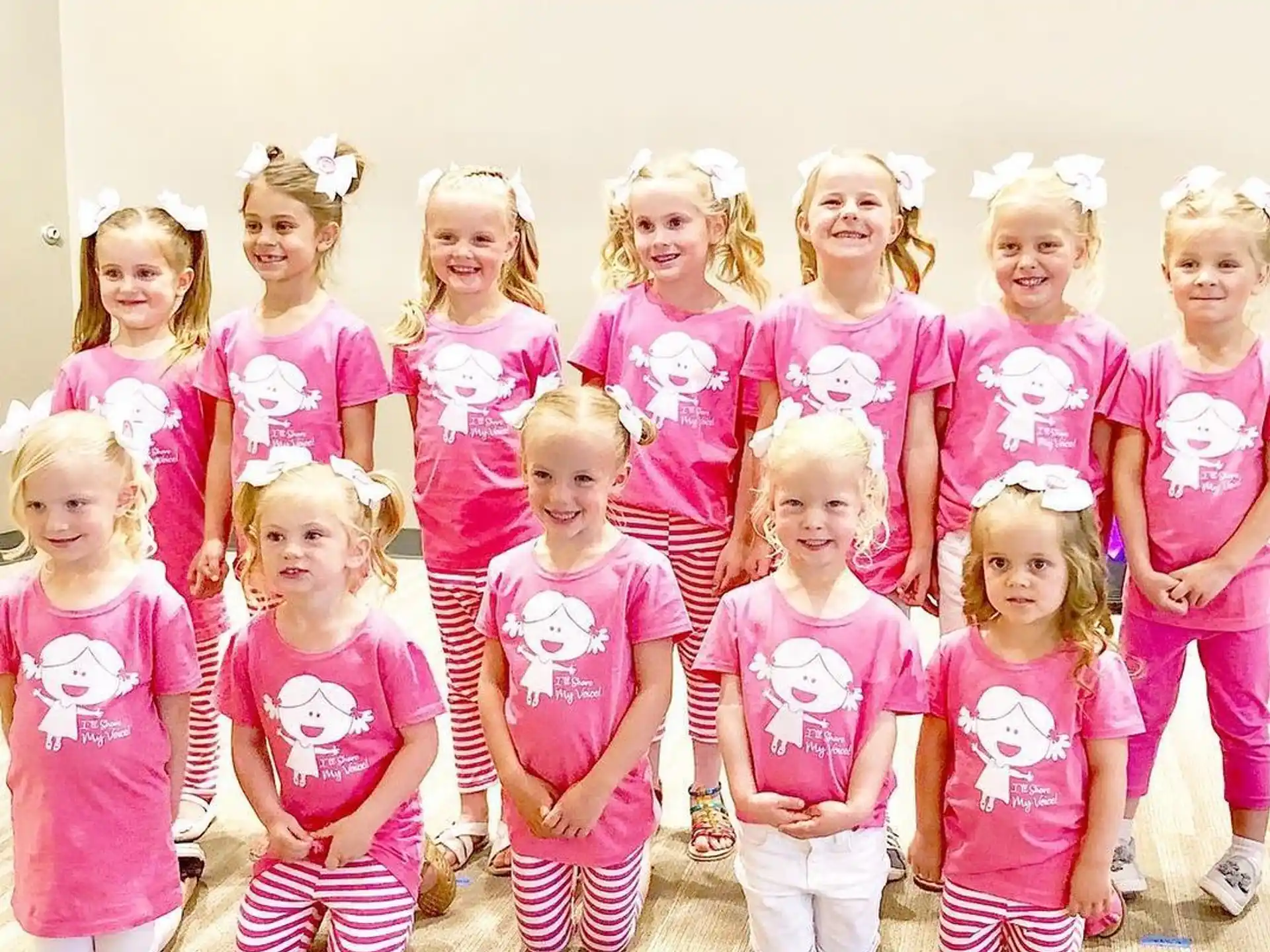 a group of children in pink and white clothes