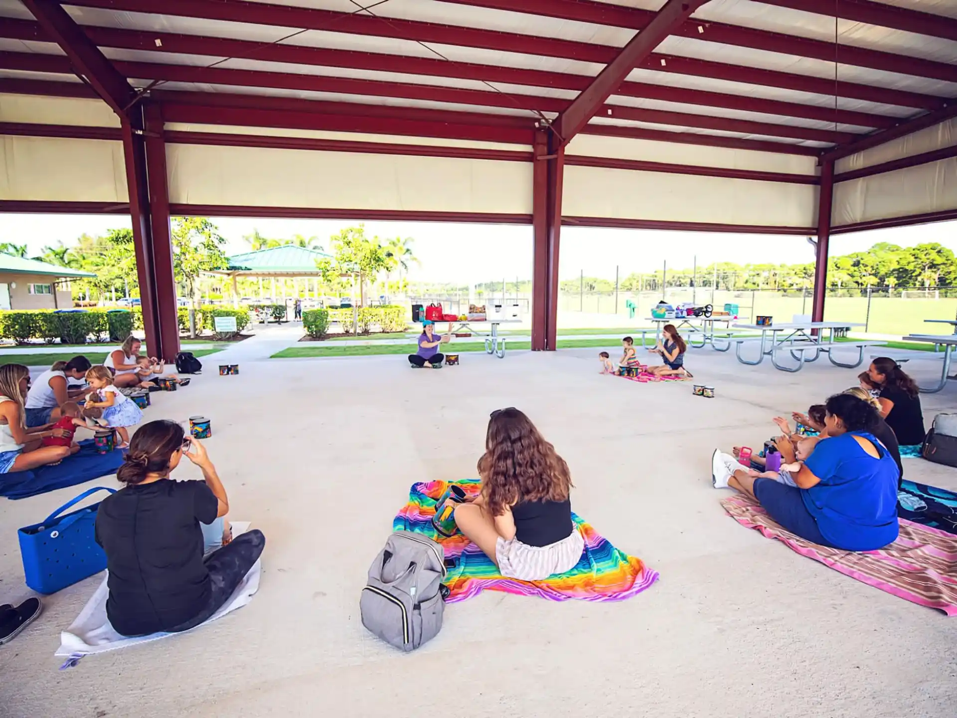 a group of people sitting on mats under a covered area