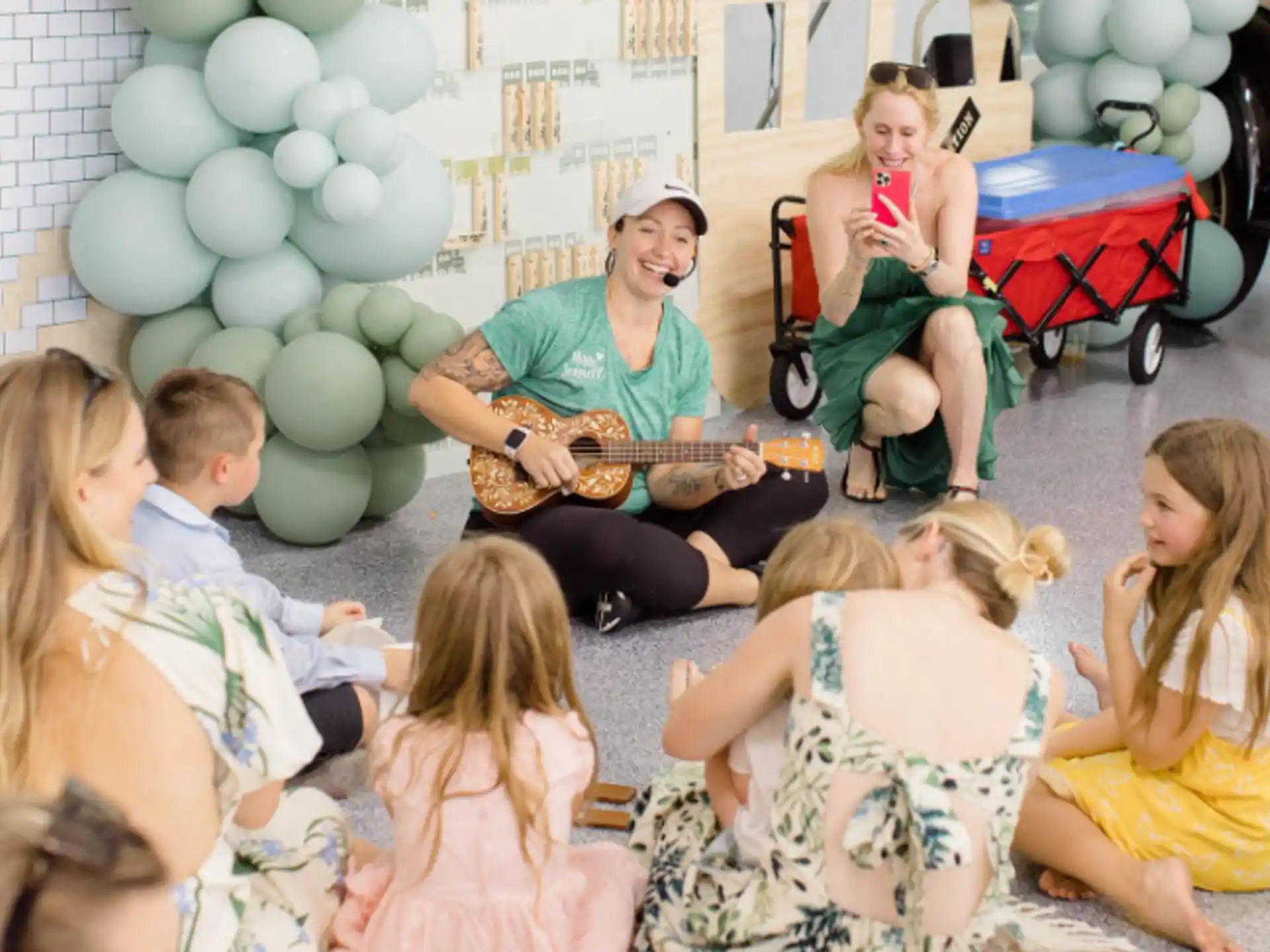 a person playing guitar to a group of children