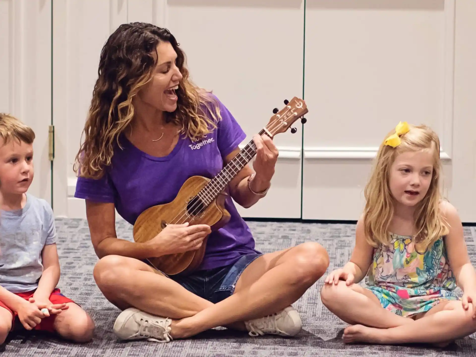 a person playing guitar with two children
