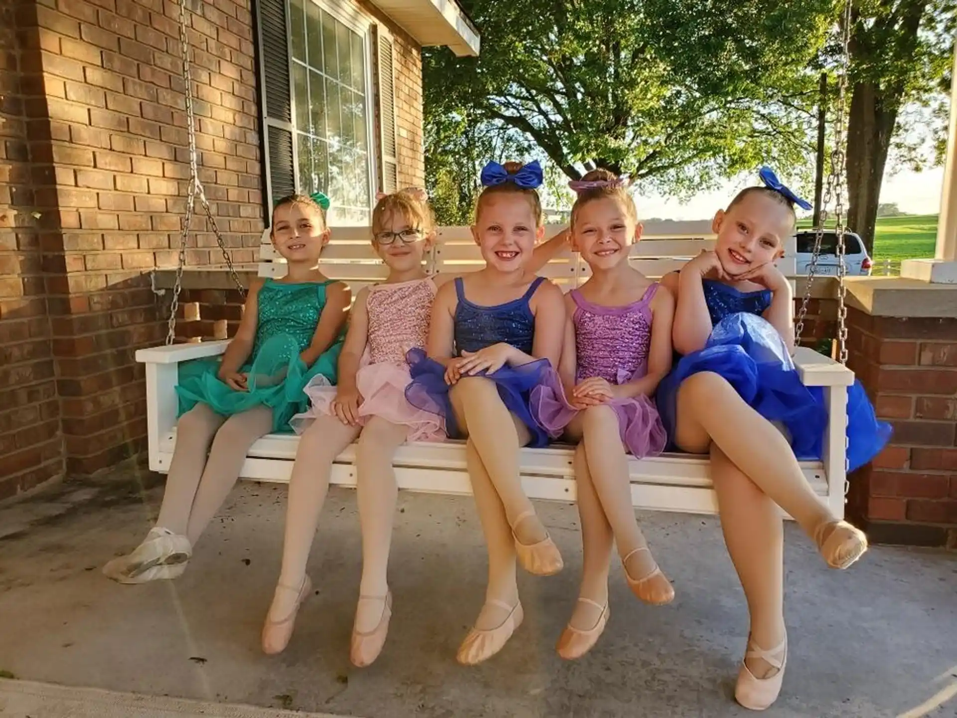 a group of girls sitting on a bench