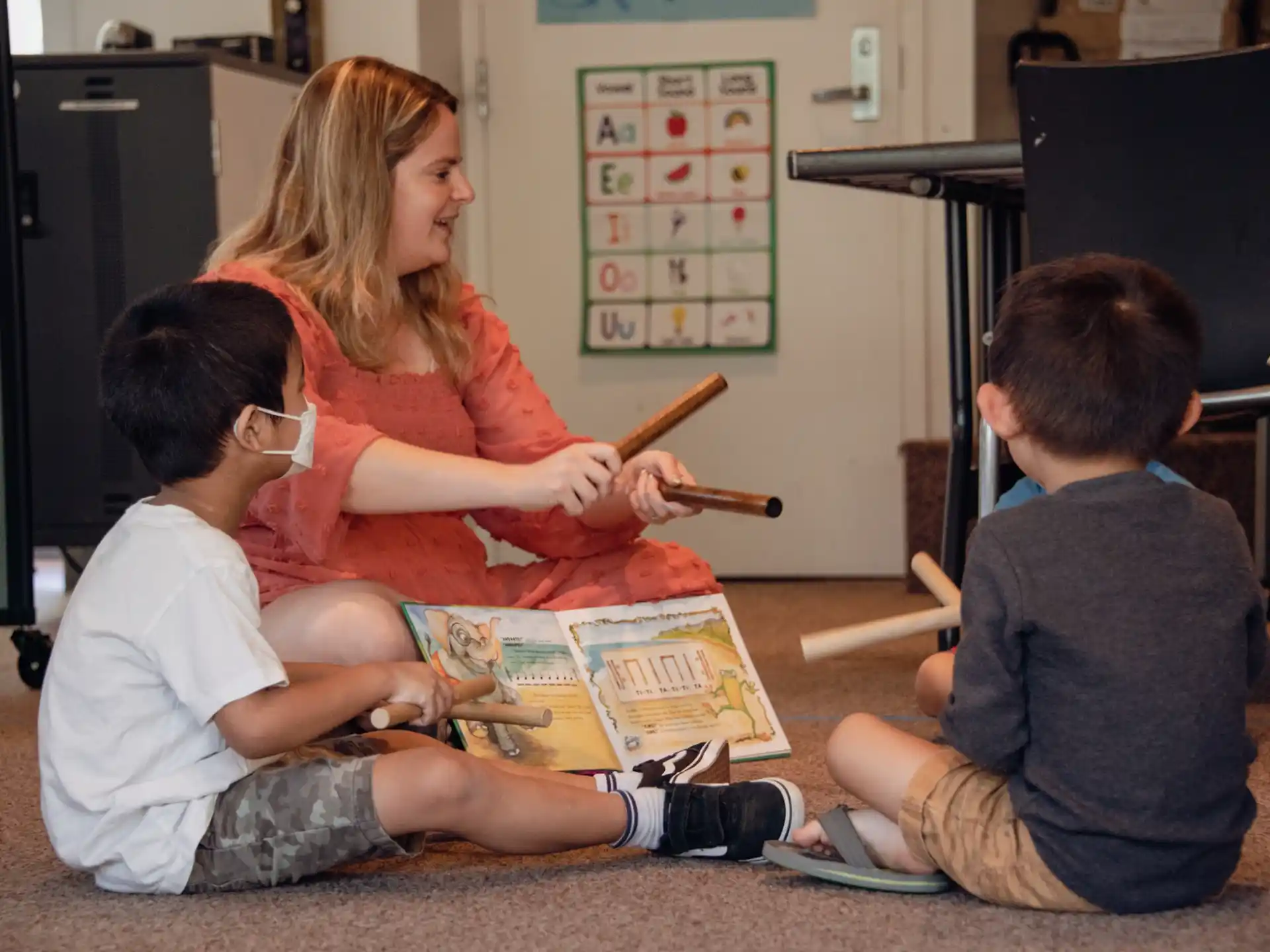 a woman teaching children how to use a toy