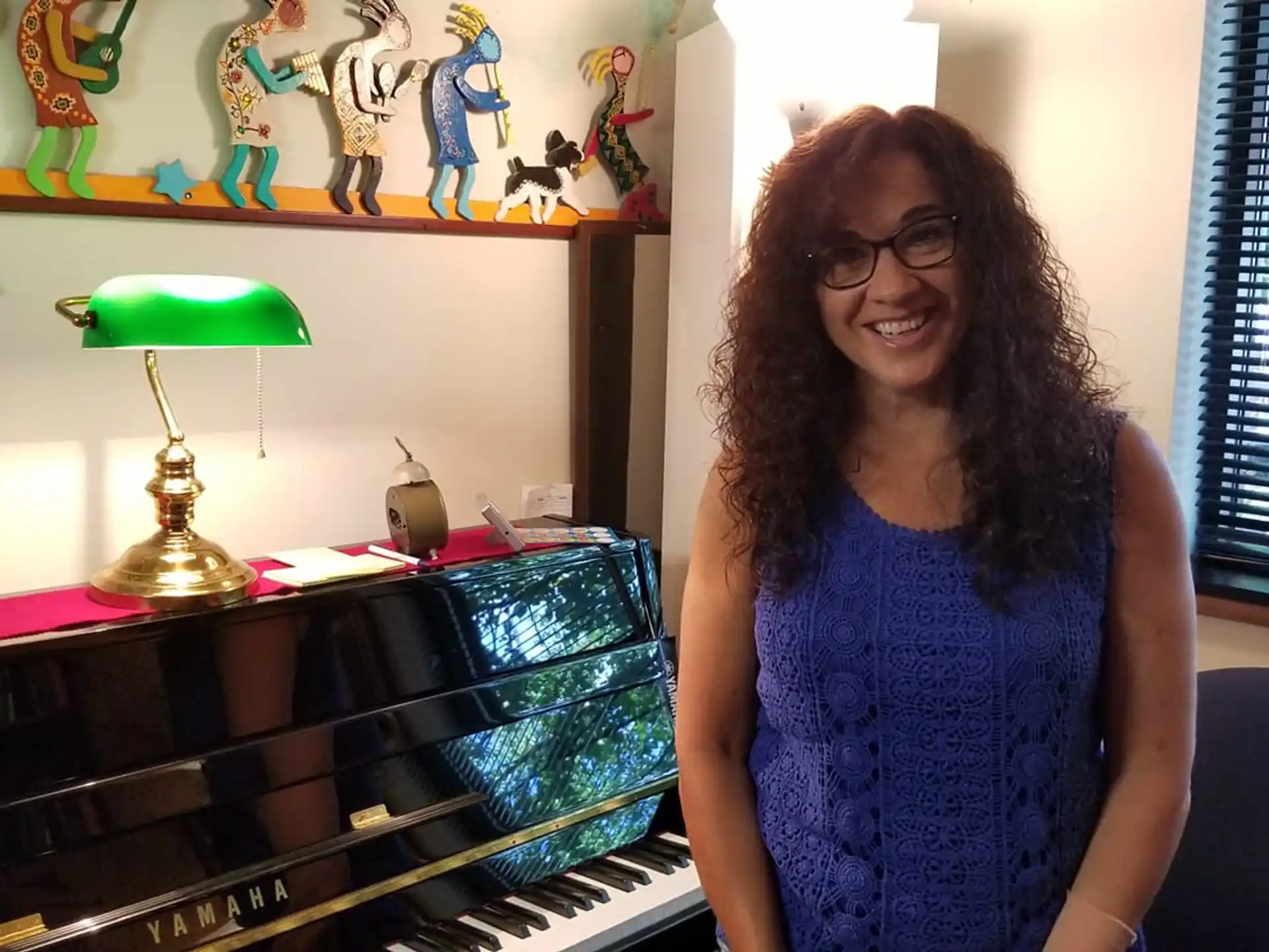 a woman smiling next to a piano