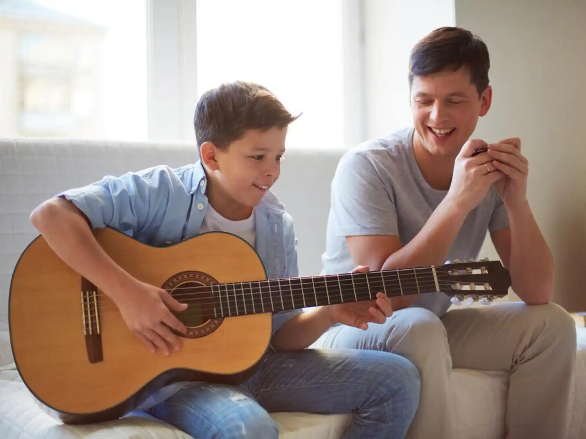 a person and a boy playing a guitar