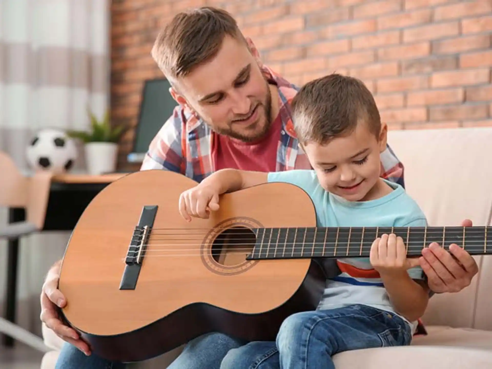 a person and a boy playing a guitar