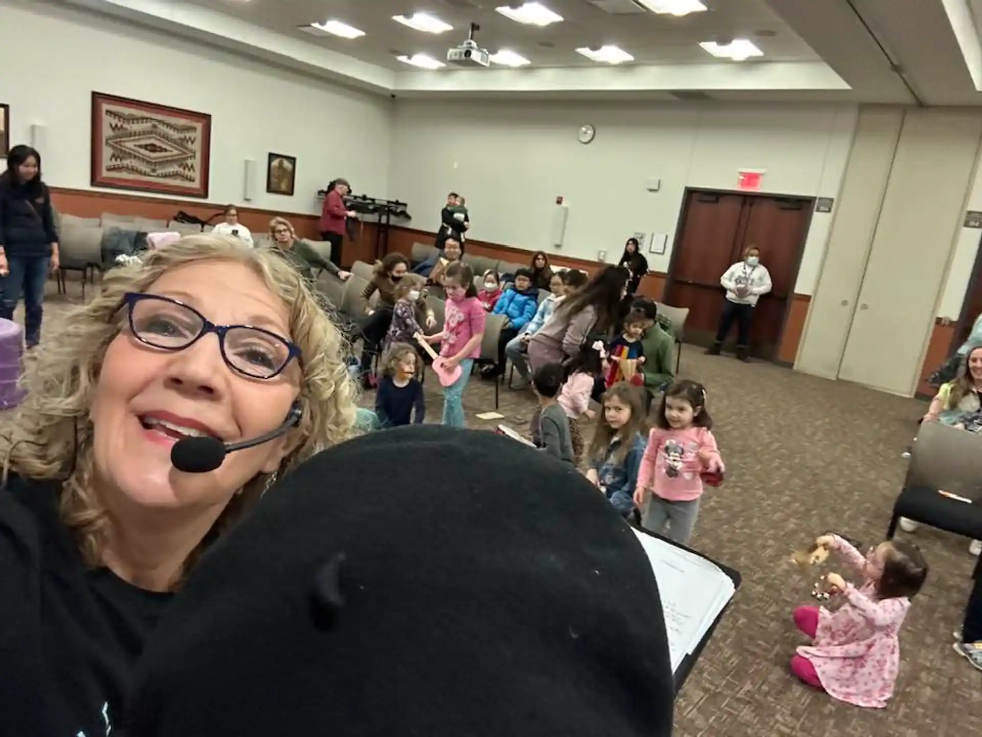 a person with a microphone in a room with a group of people