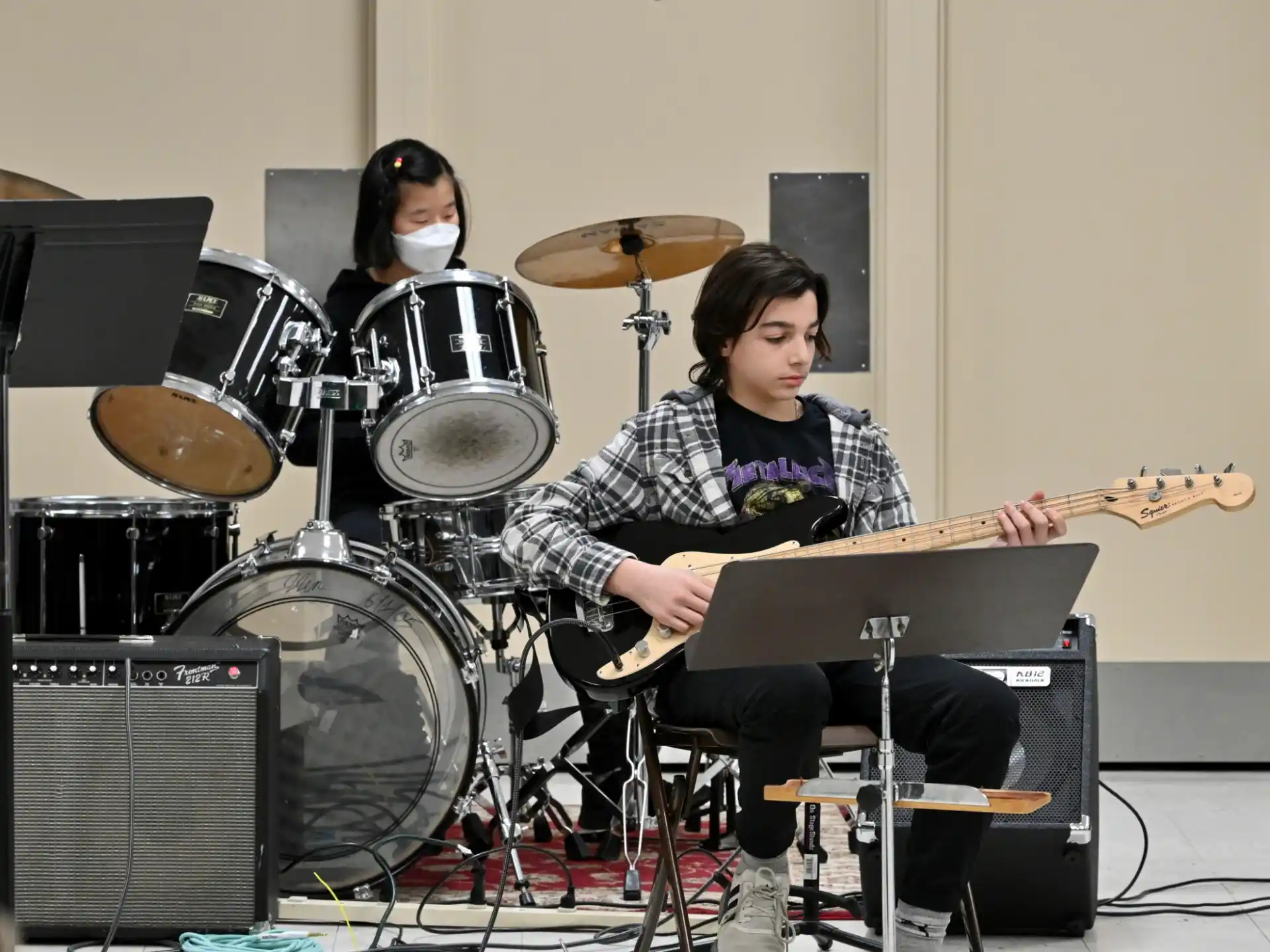 a man playing a guitar next to a woman playing drums