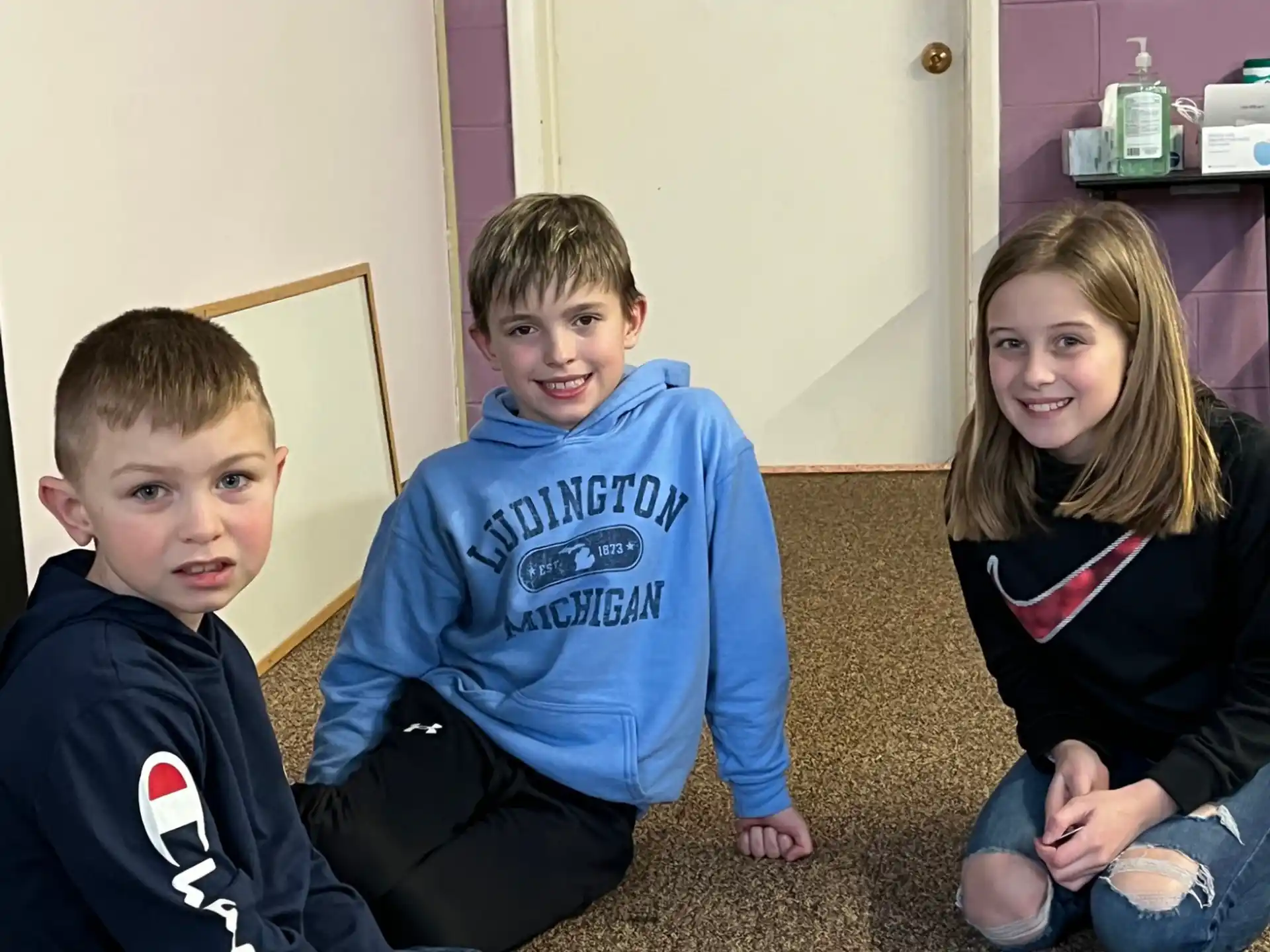 a group of children sitting on the floor playing a board game