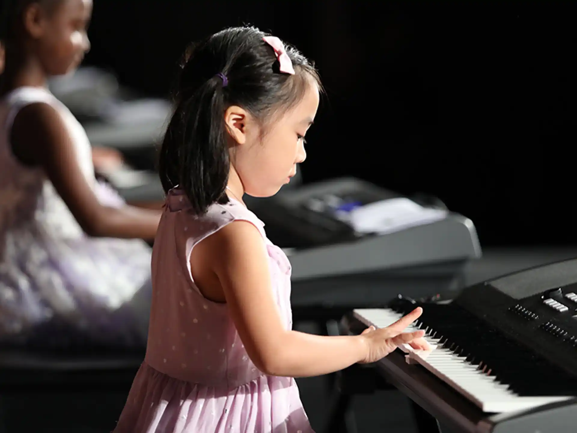 a young girl playing a piano