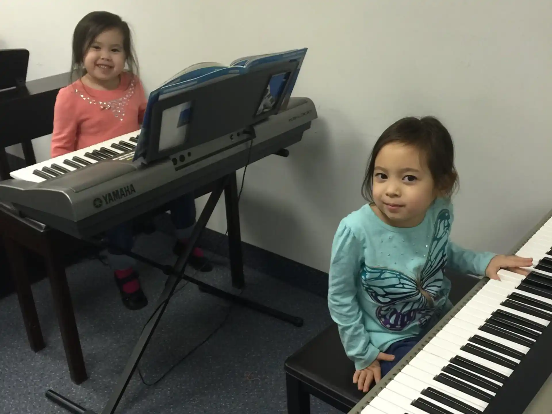 a couple of girls playing piano