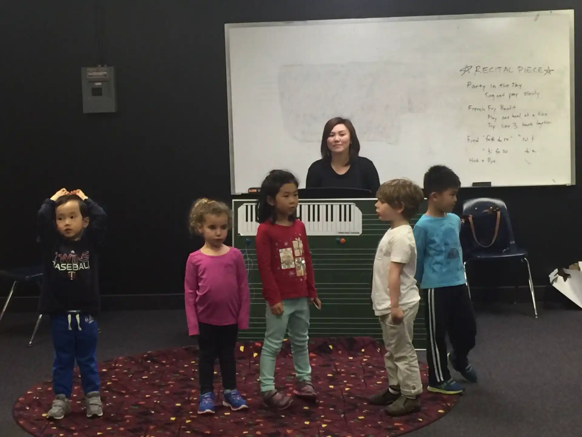 a group of children standing in front of a whiteboard