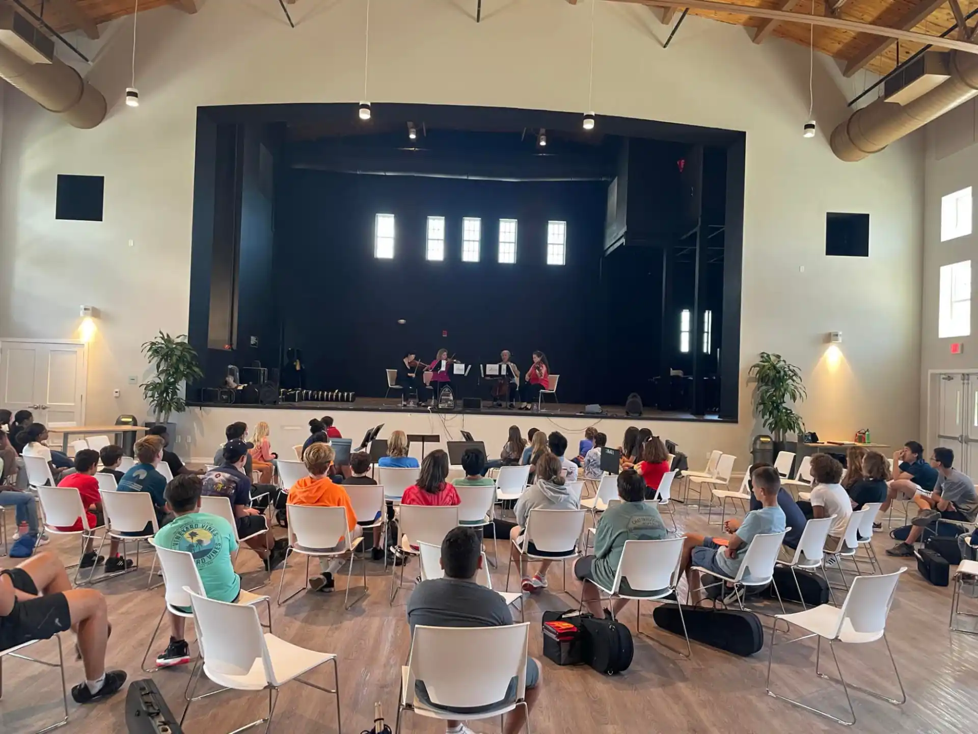 a group of people sitting in chairs in front of a stage