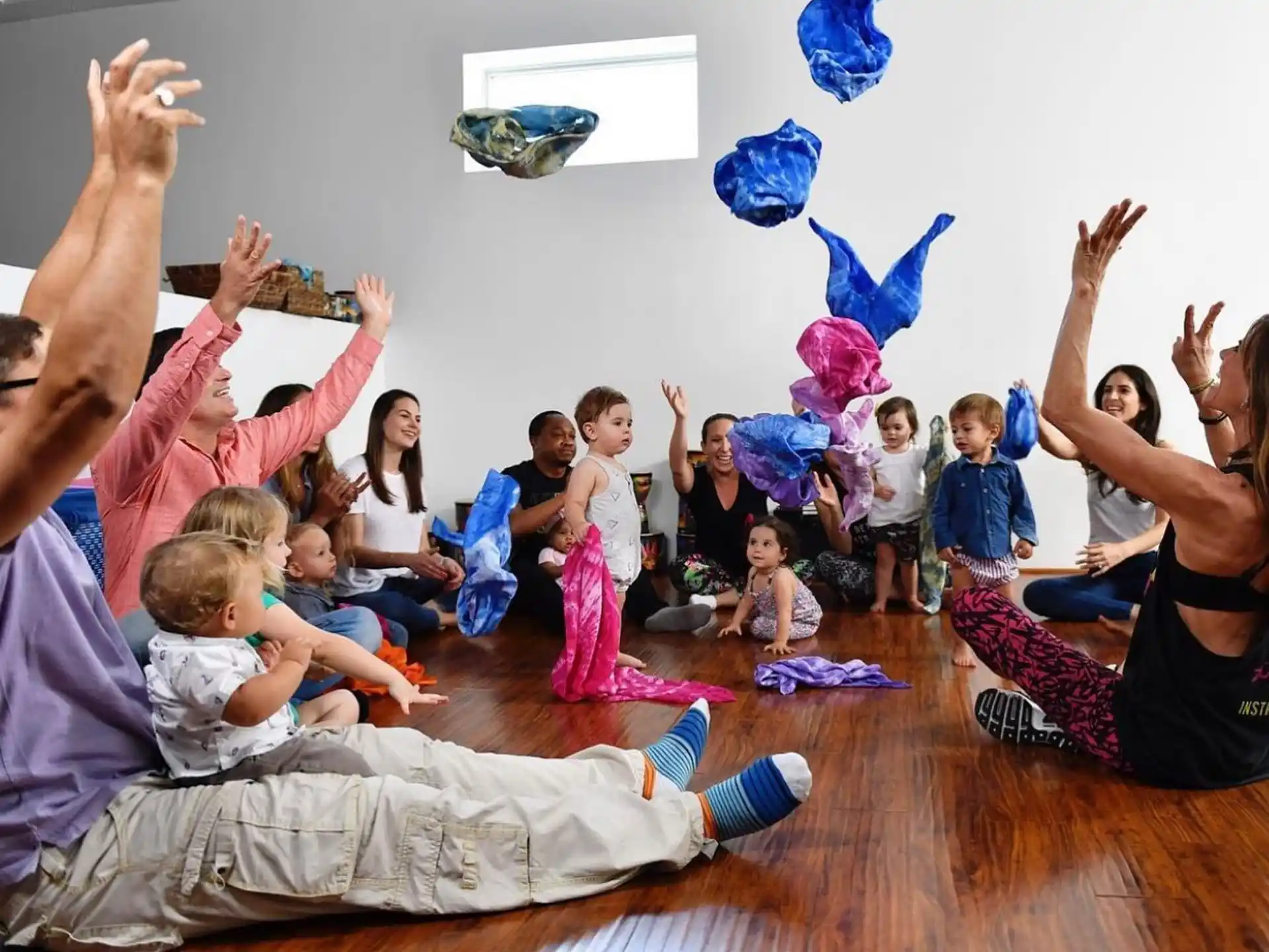 a group of children in a circle with their hands up