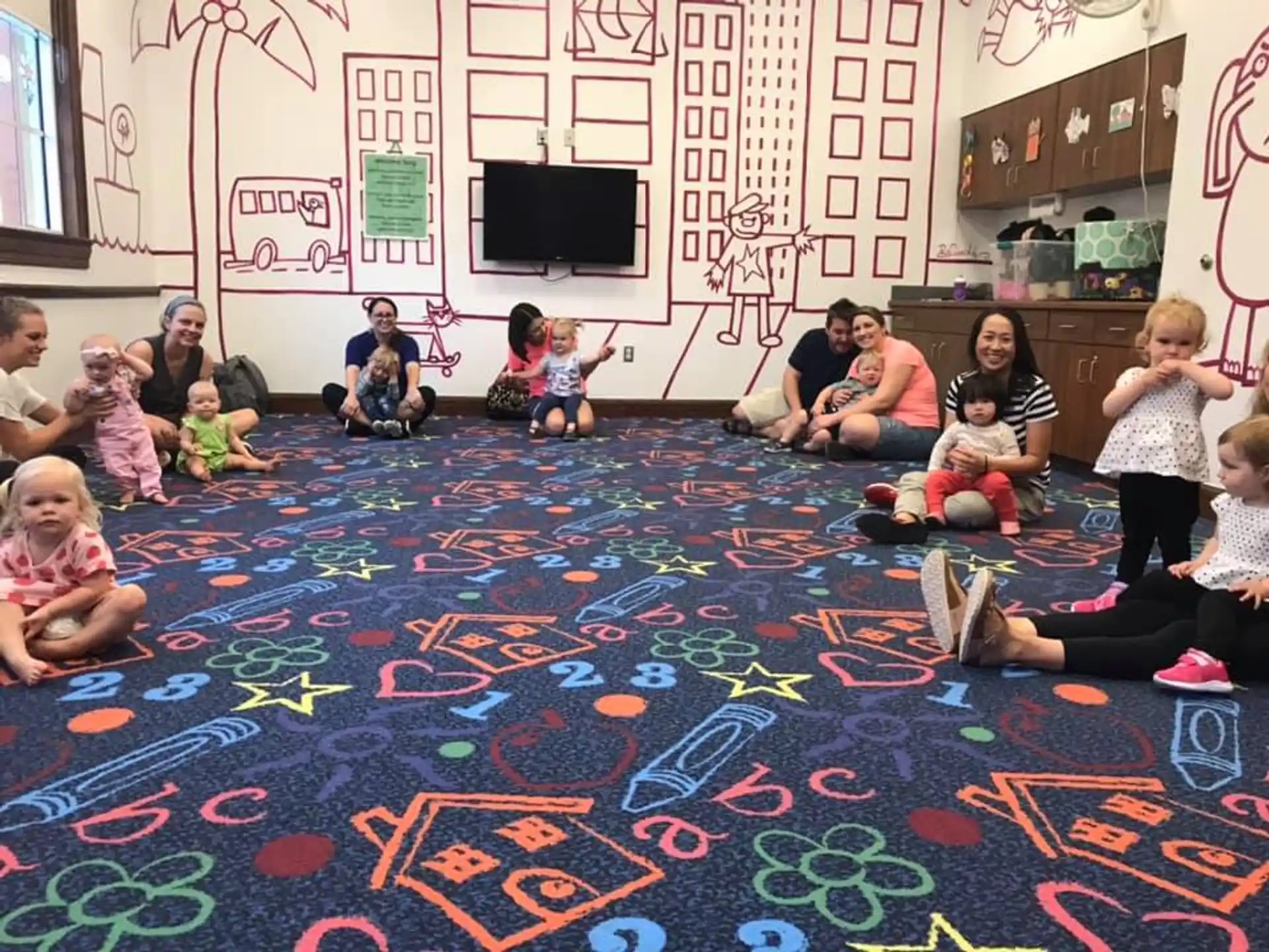 a group of children sitting on the floor in a classroom