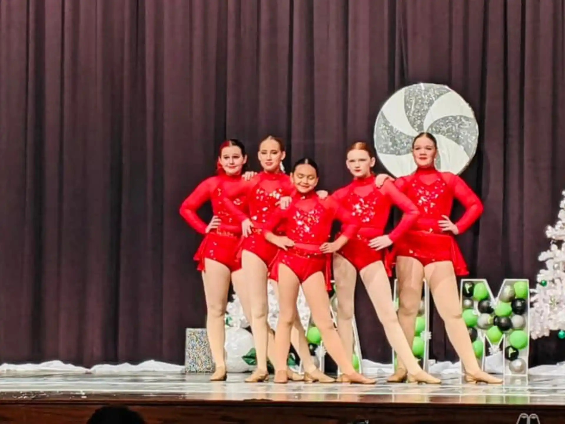 a group of women in red and white outfits on a stage
