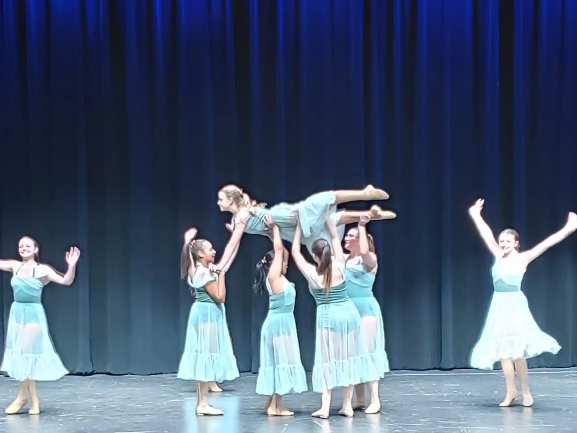 a group of girls dancing on a stage