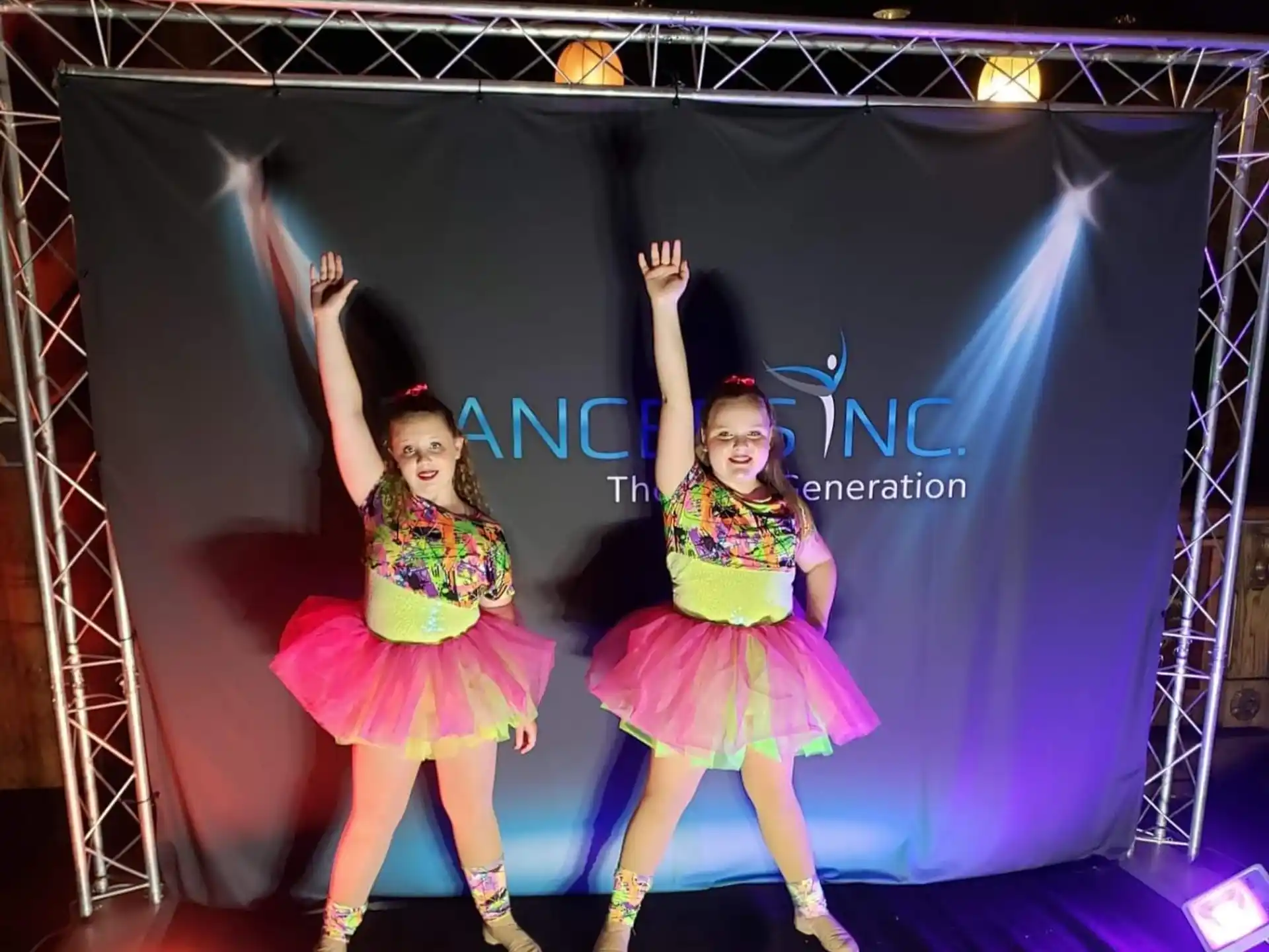 two women in dresses dancing on a stage