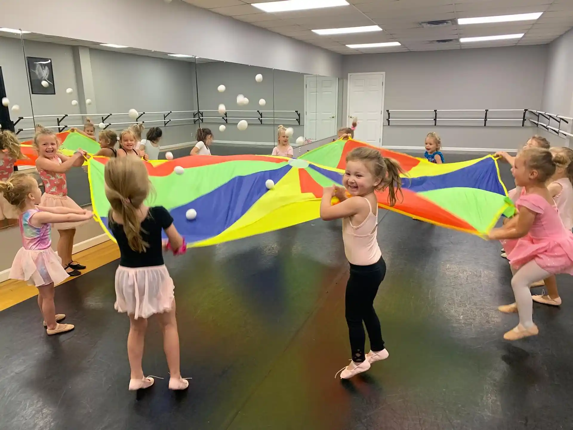 a group of children holding a rainbow colored flag
