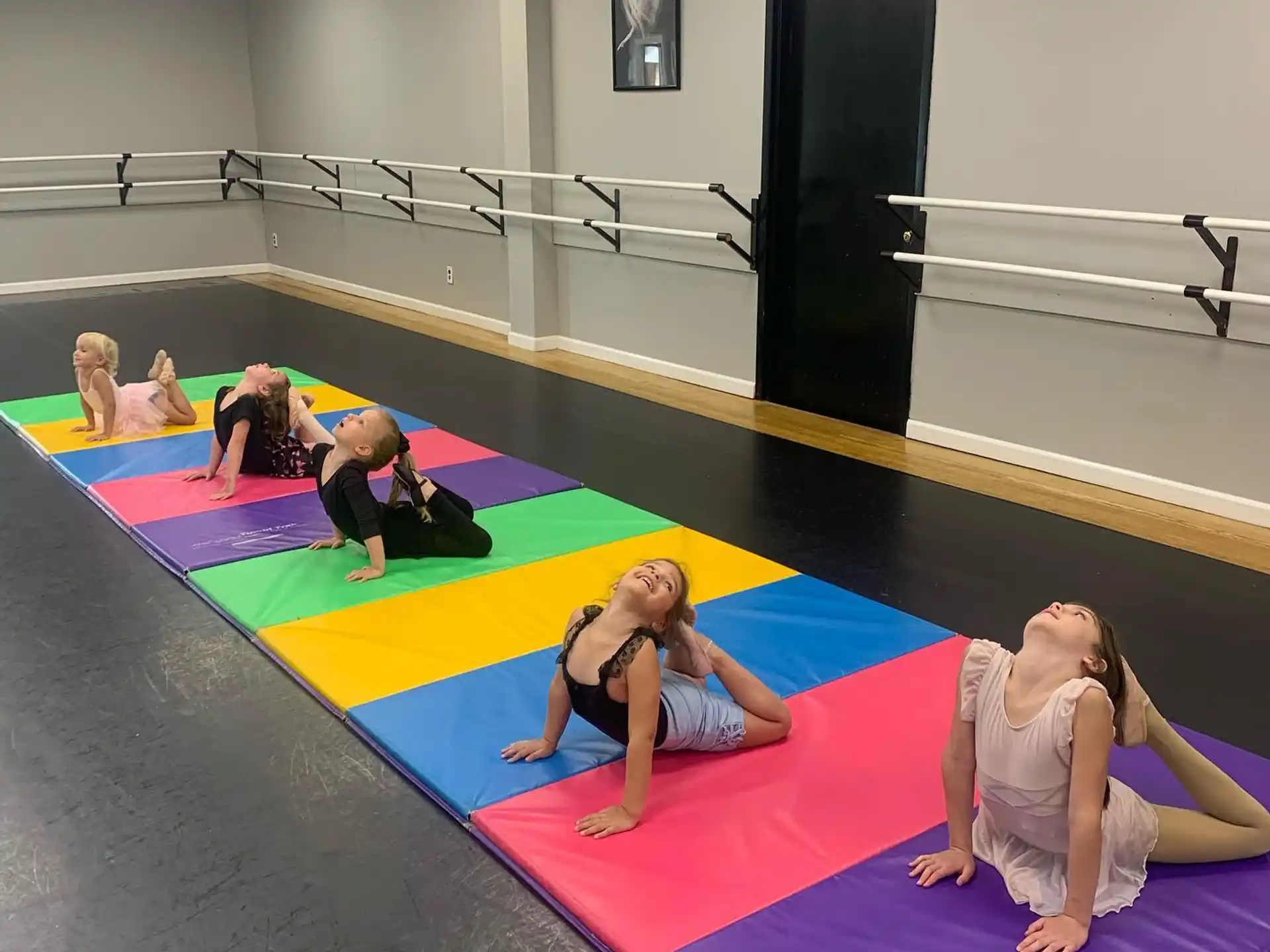 a group of women exercising on a mat in a gym