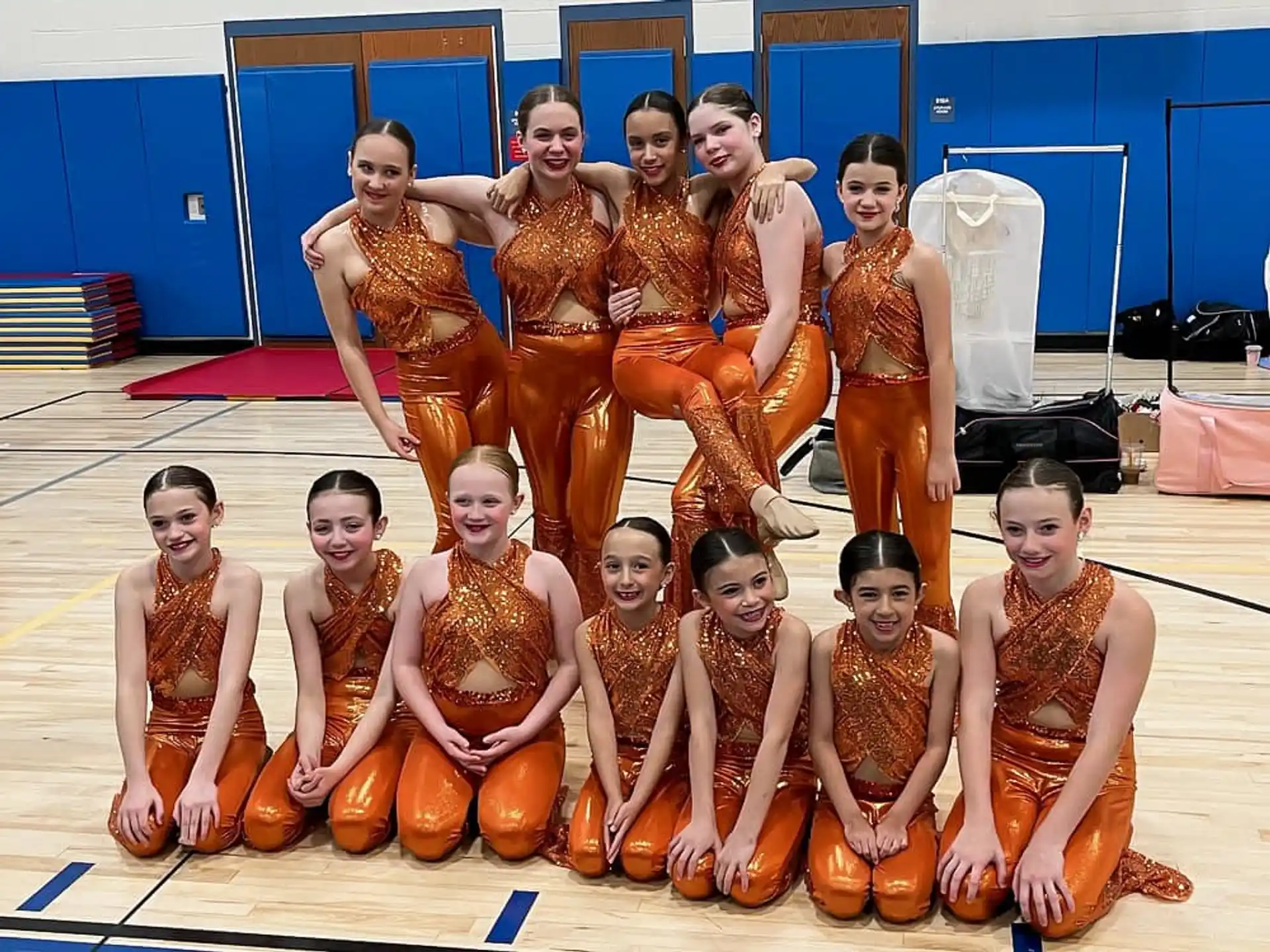 a group of women in orange dresses