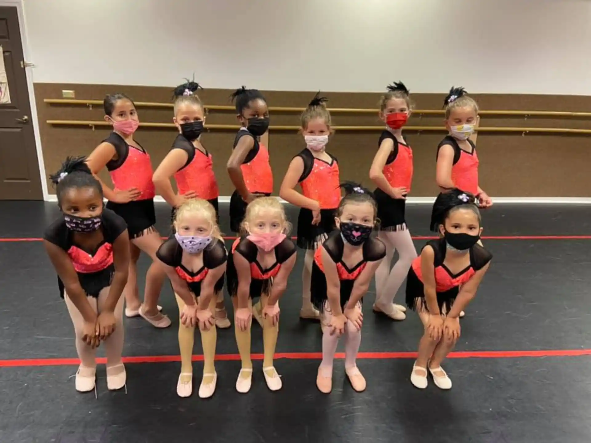 a group of girls in red and white uniforms on a gym floor