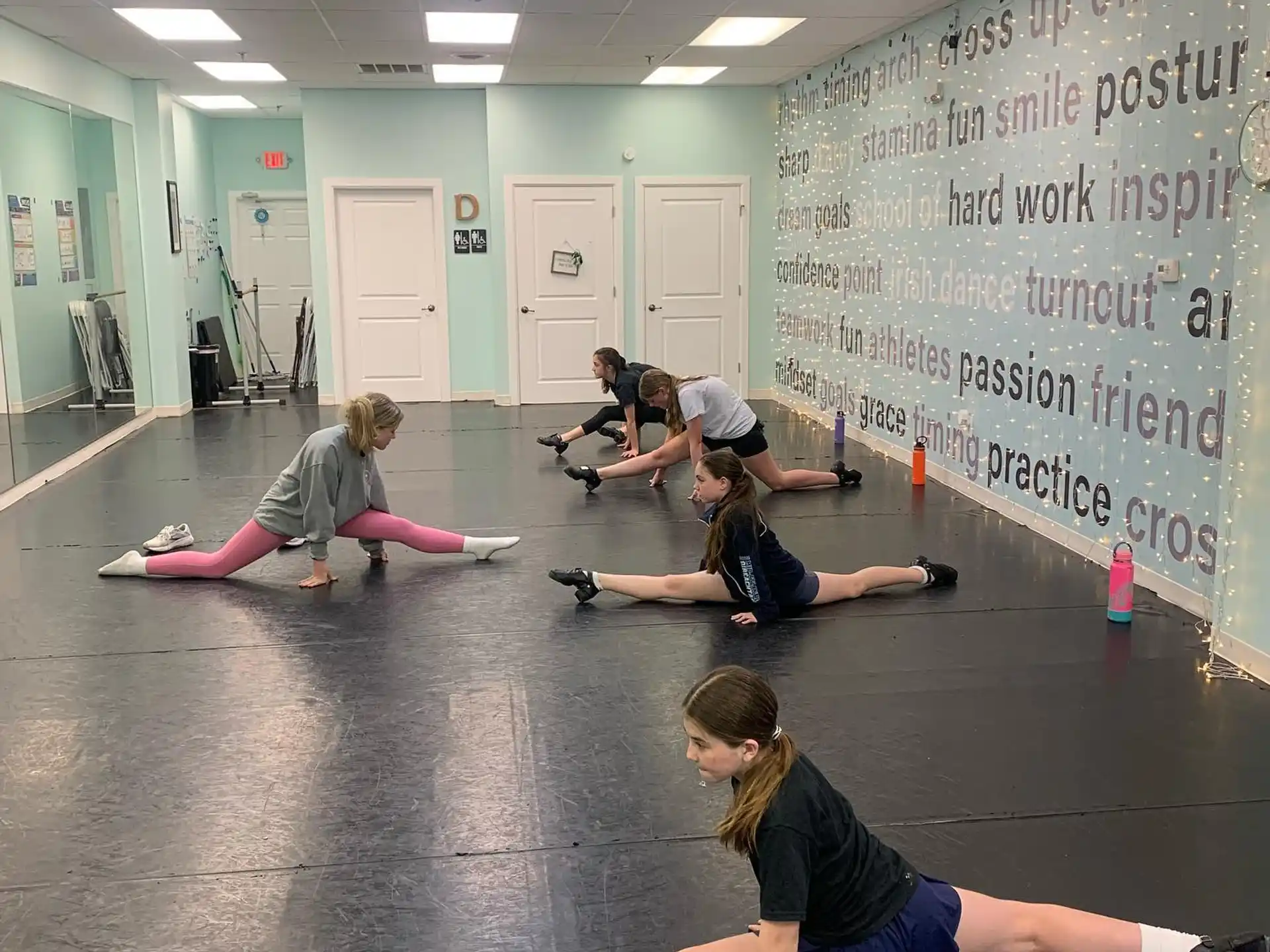 a group of people exercising in a room with whiteboards