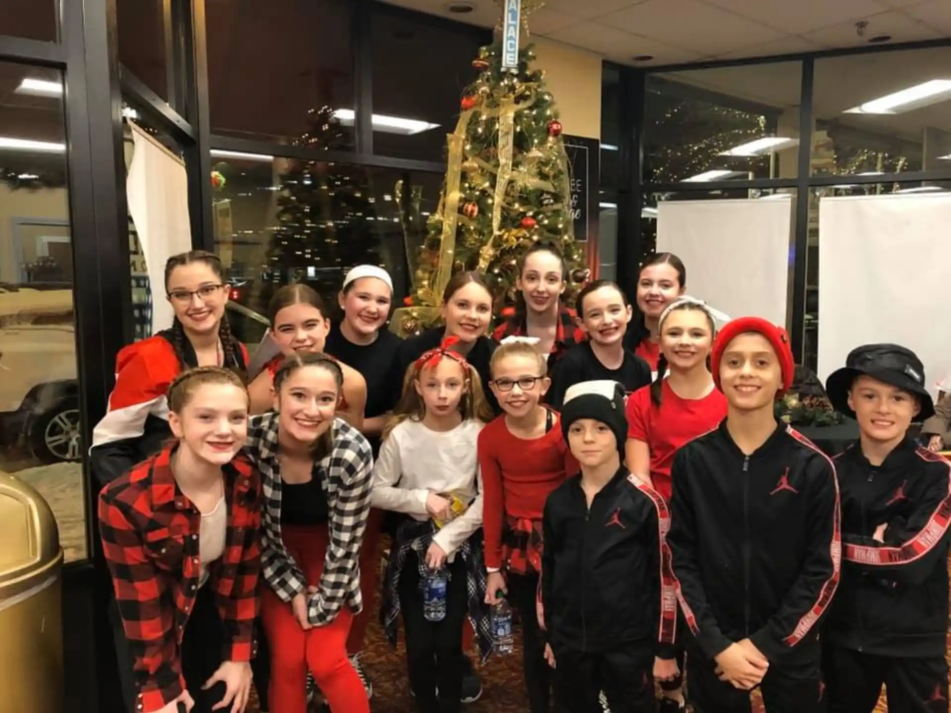 a group of people posing for a photo in front of a christmas tree