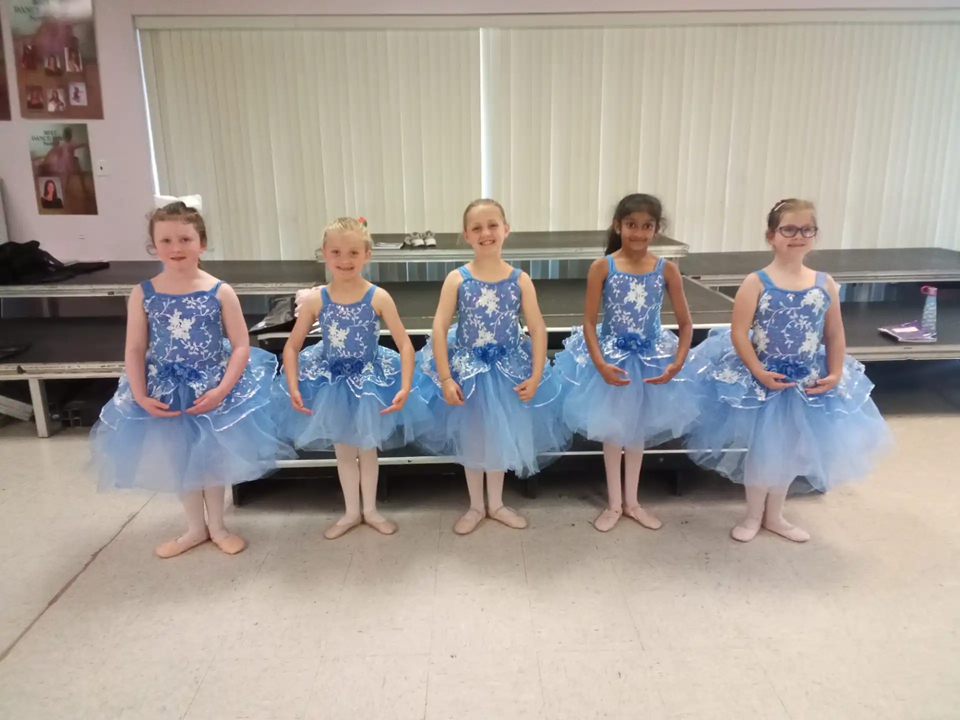 a group of girls in blue dresses