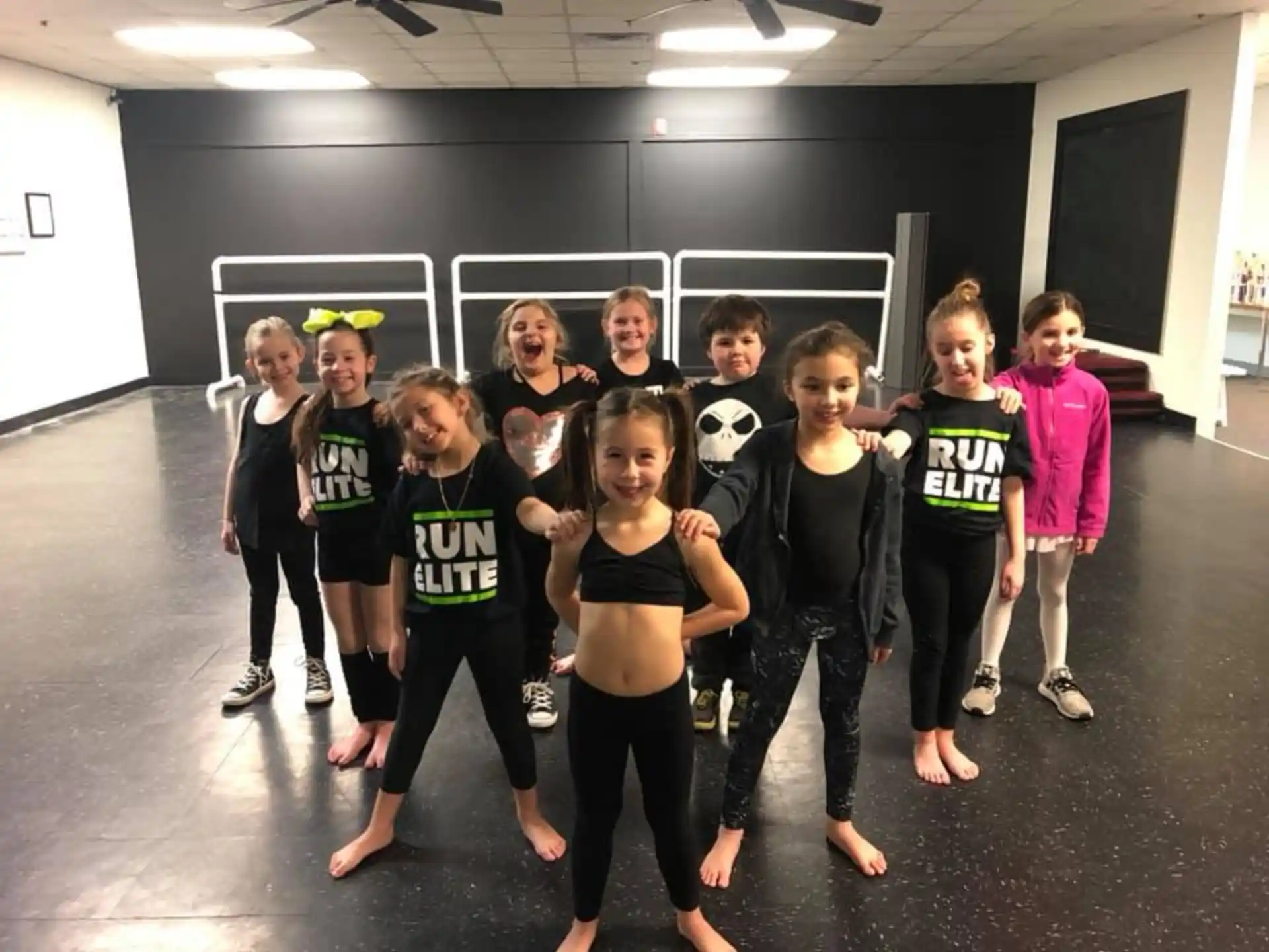 a group of children wearing matching t-shirts and standing in a room