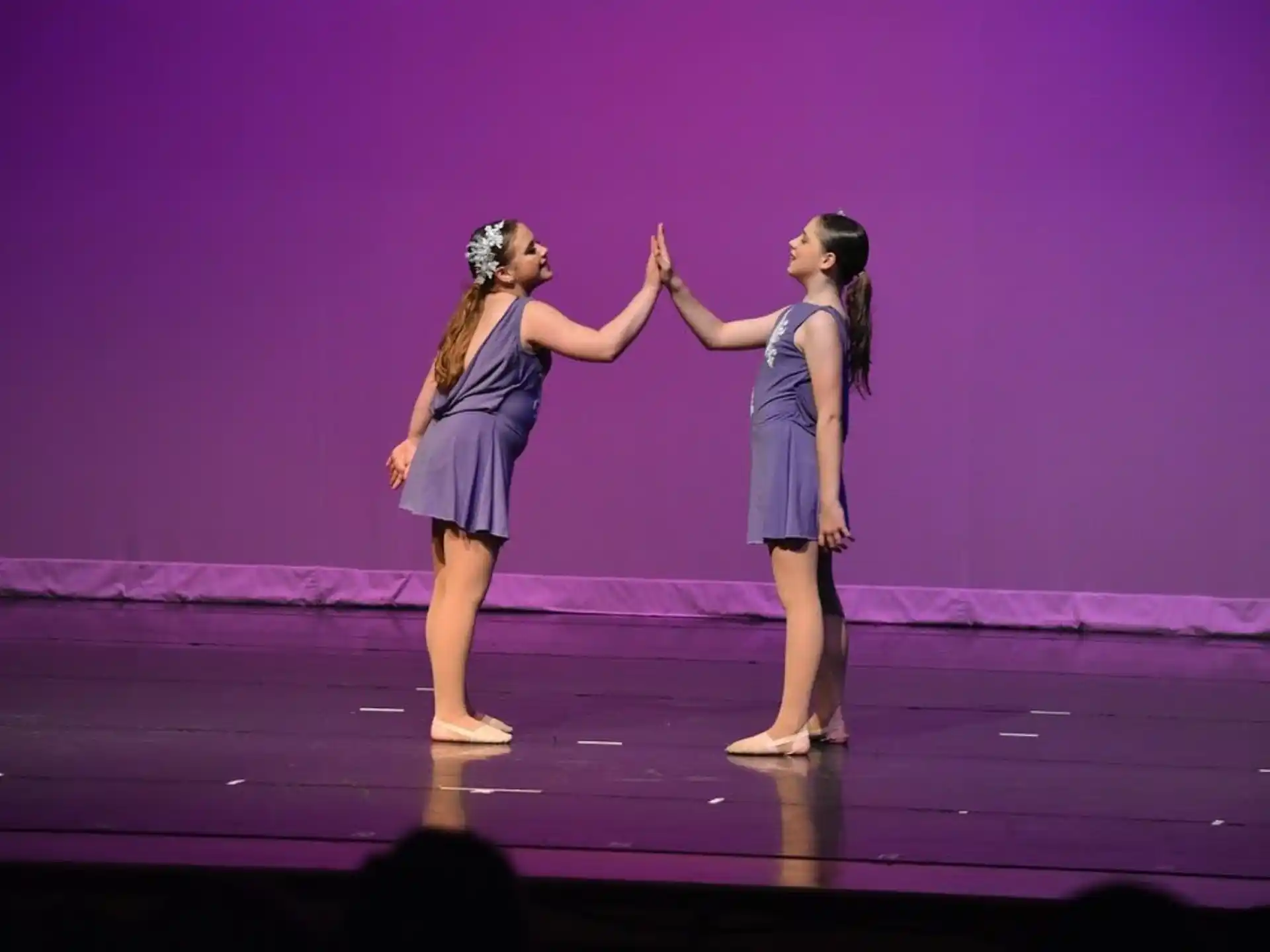 two women in blue dresses on a stage