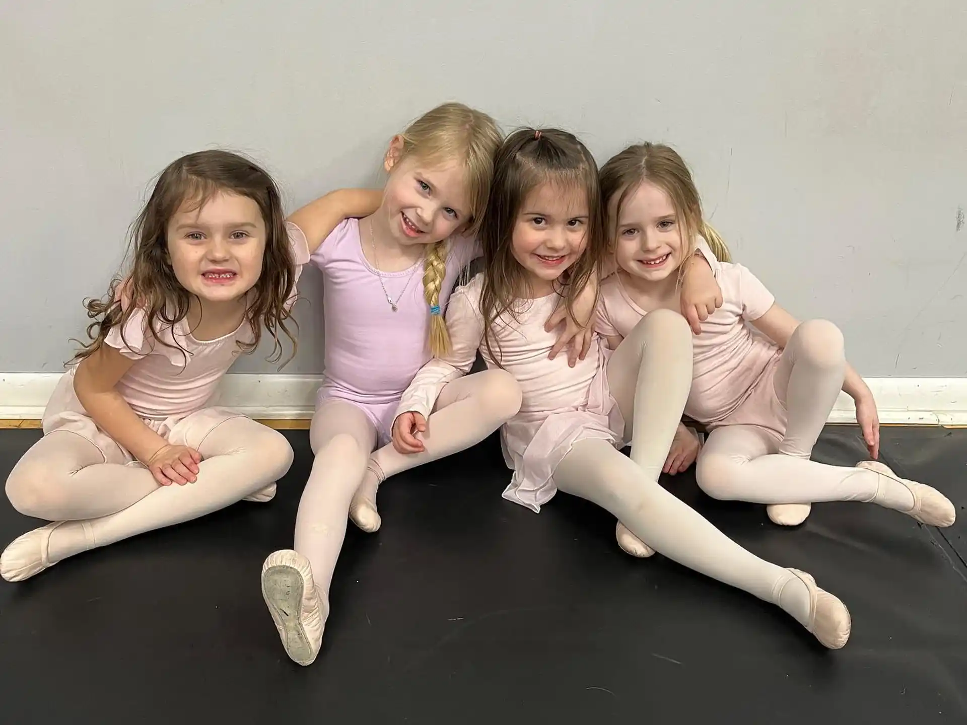 a group of girls sitting on a black surface