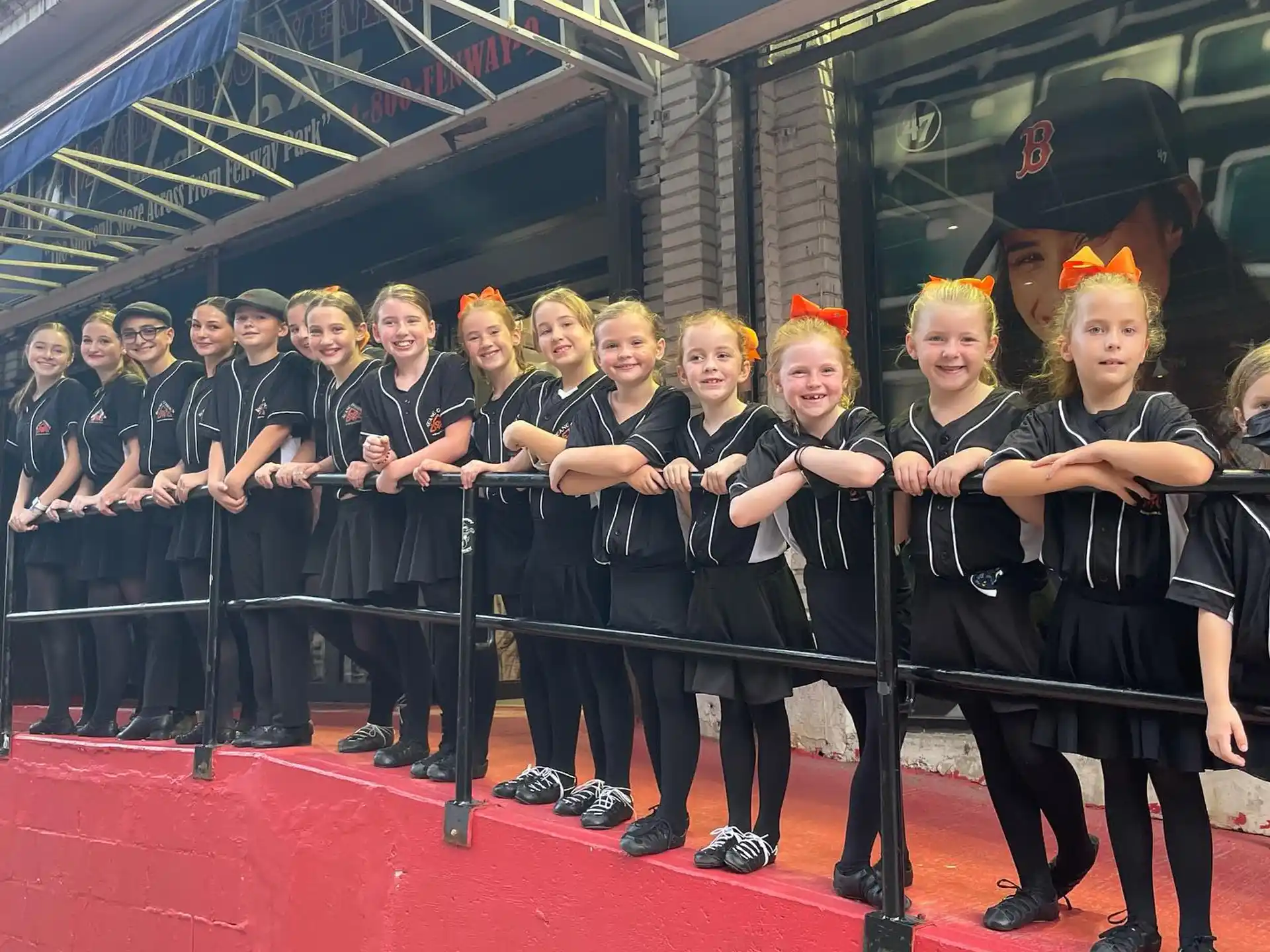 a group of people in black and yellow uniforms standing on a red carpet