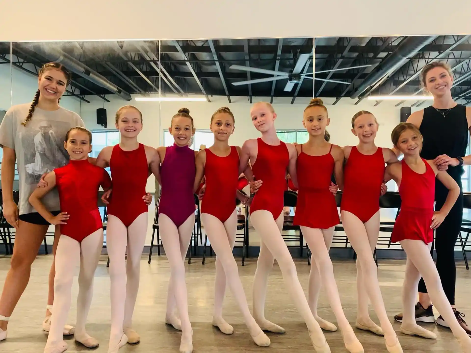 a group of women in red and black leotards posing for a photo