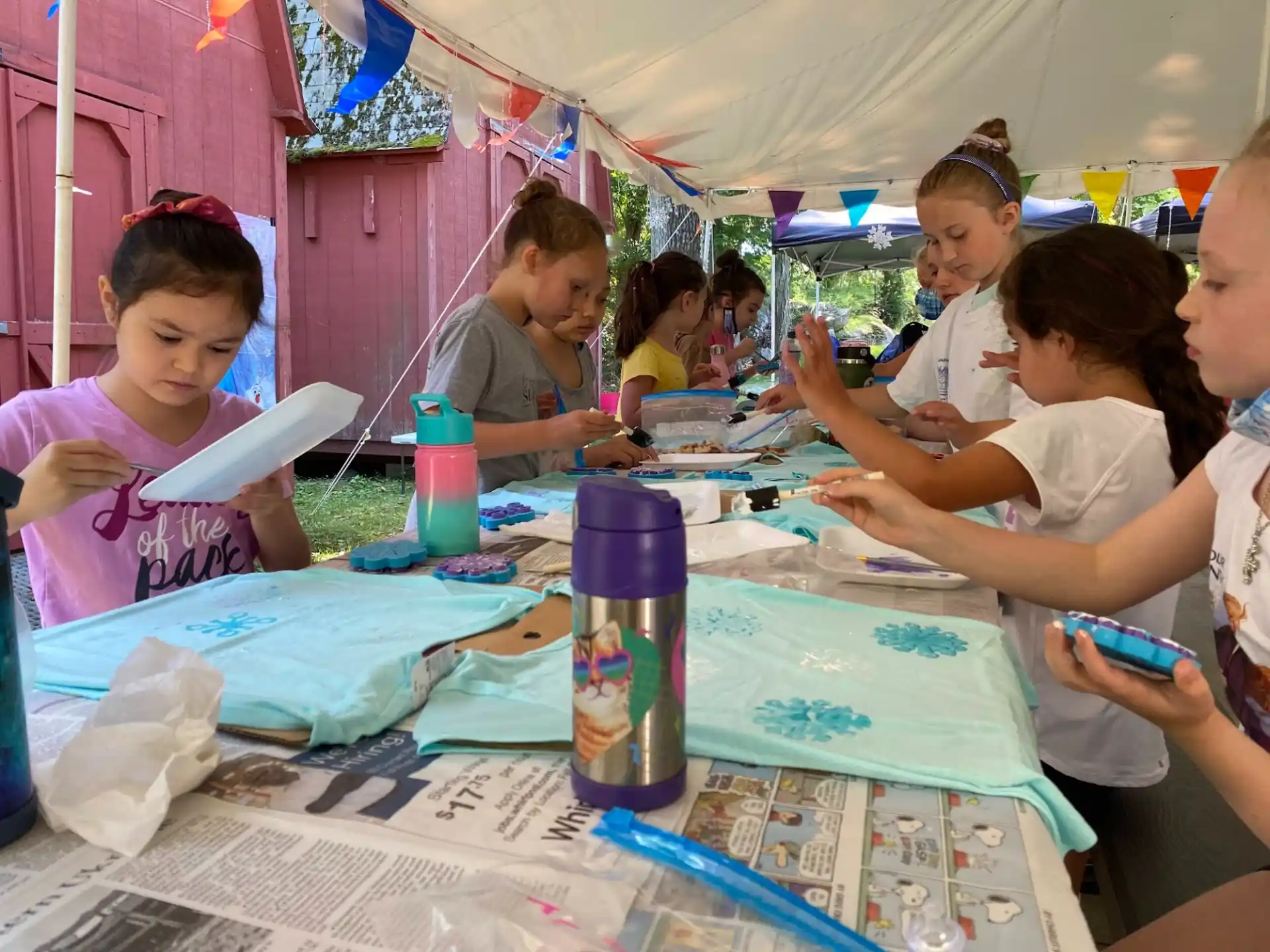 a group of people sitting at a table with blue and white objects