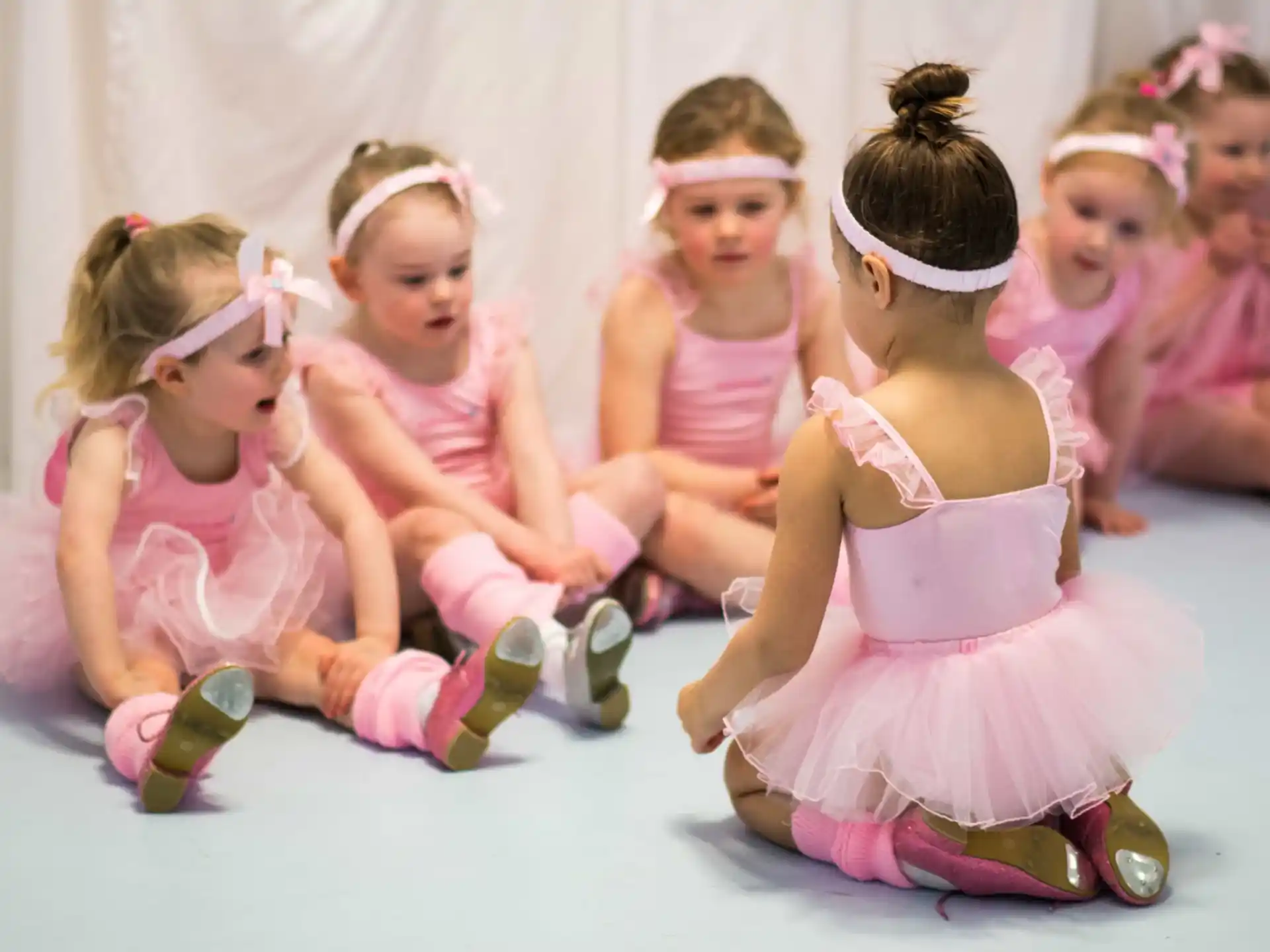 a group of girls wearing pink dresses