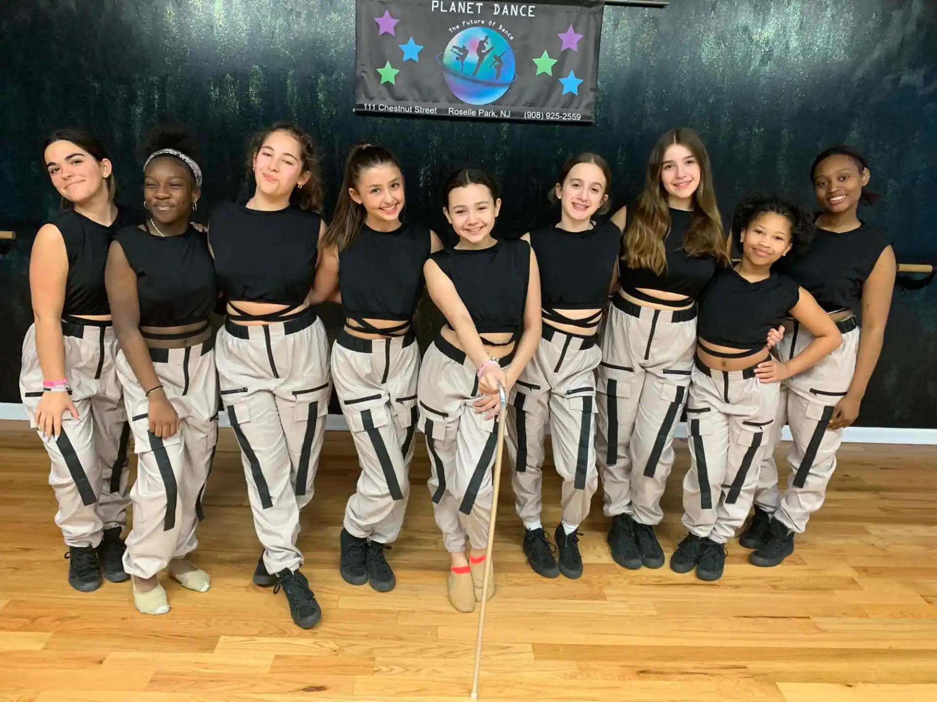 a group of girls in black and white uniforms posing for a photo