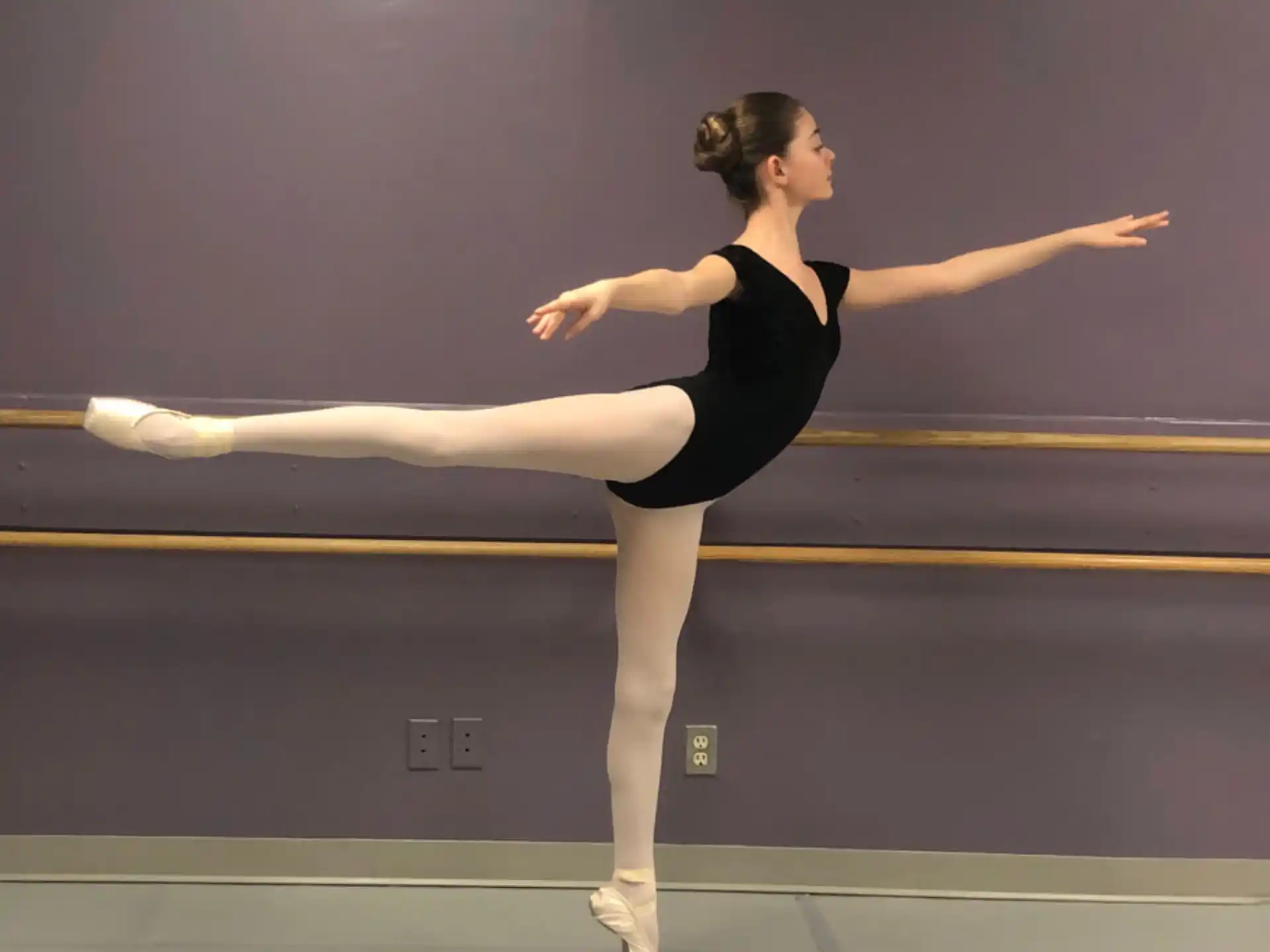a woman in a leotard stretching her leg