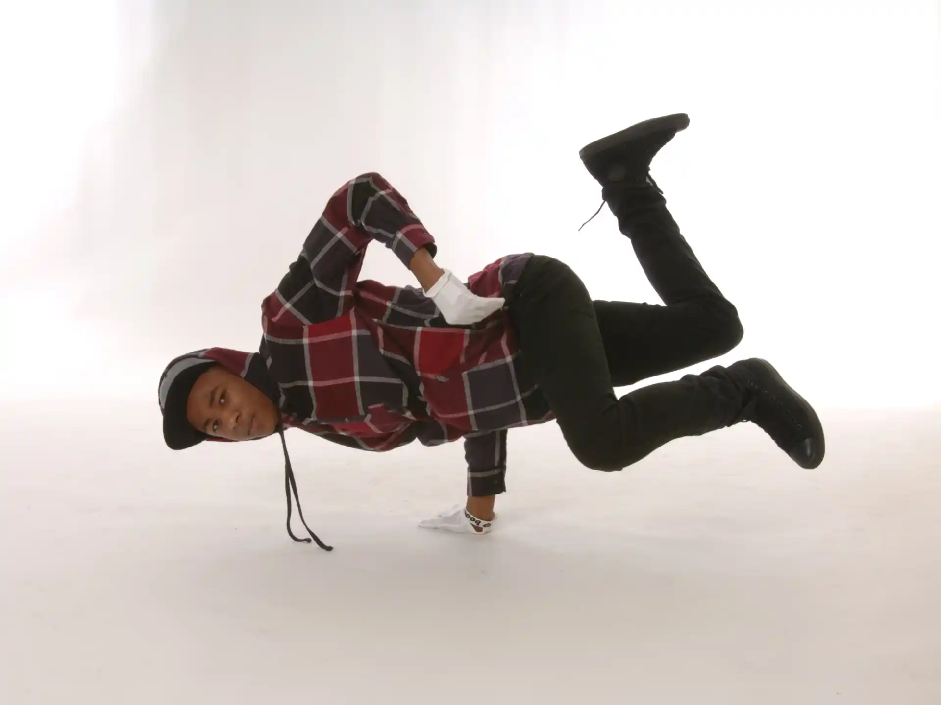 a person in a red and black plaid shirt and black pants on a white background