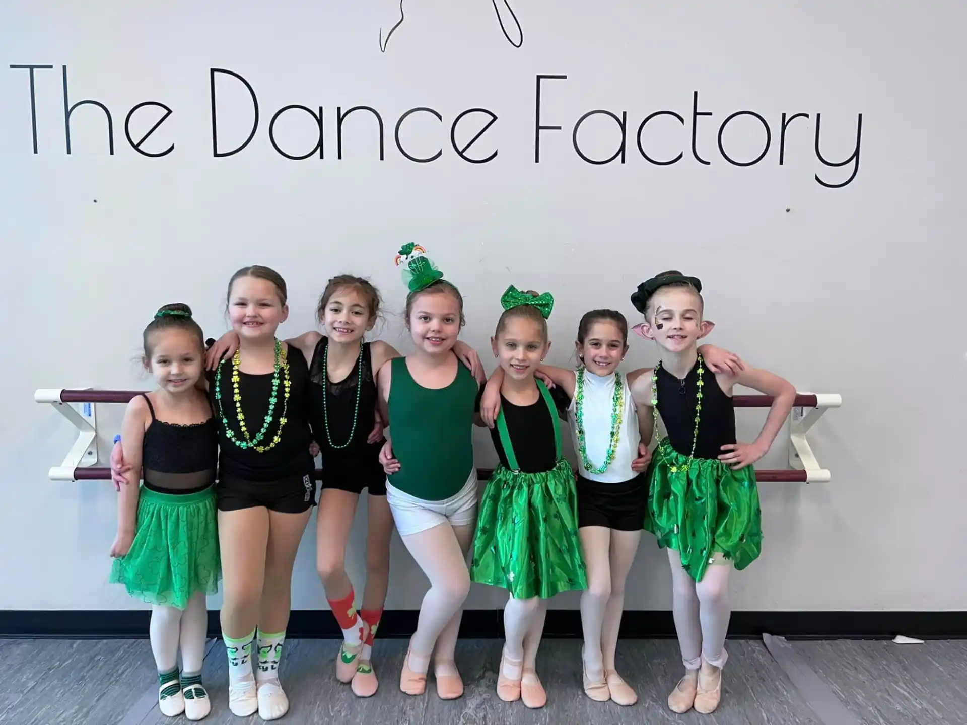 a group of girls in matching green and black uniforms