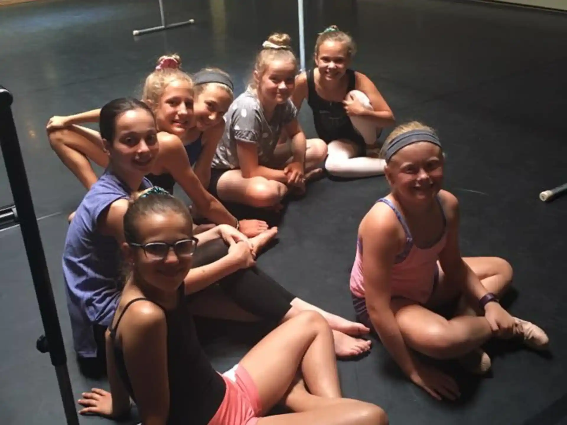 a group of people sitting on a trampoline posing for the camera