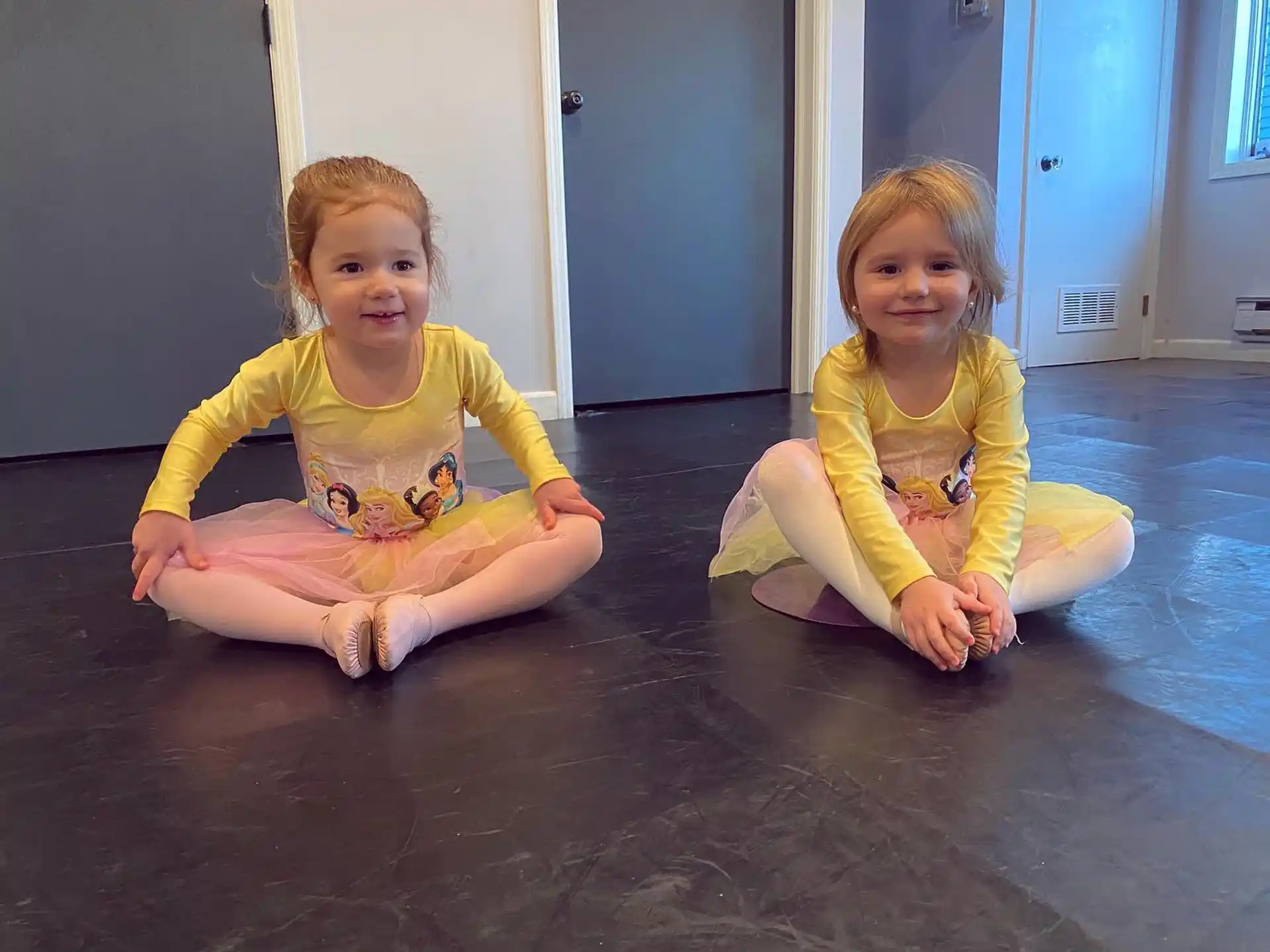 two girls sitting on the floor