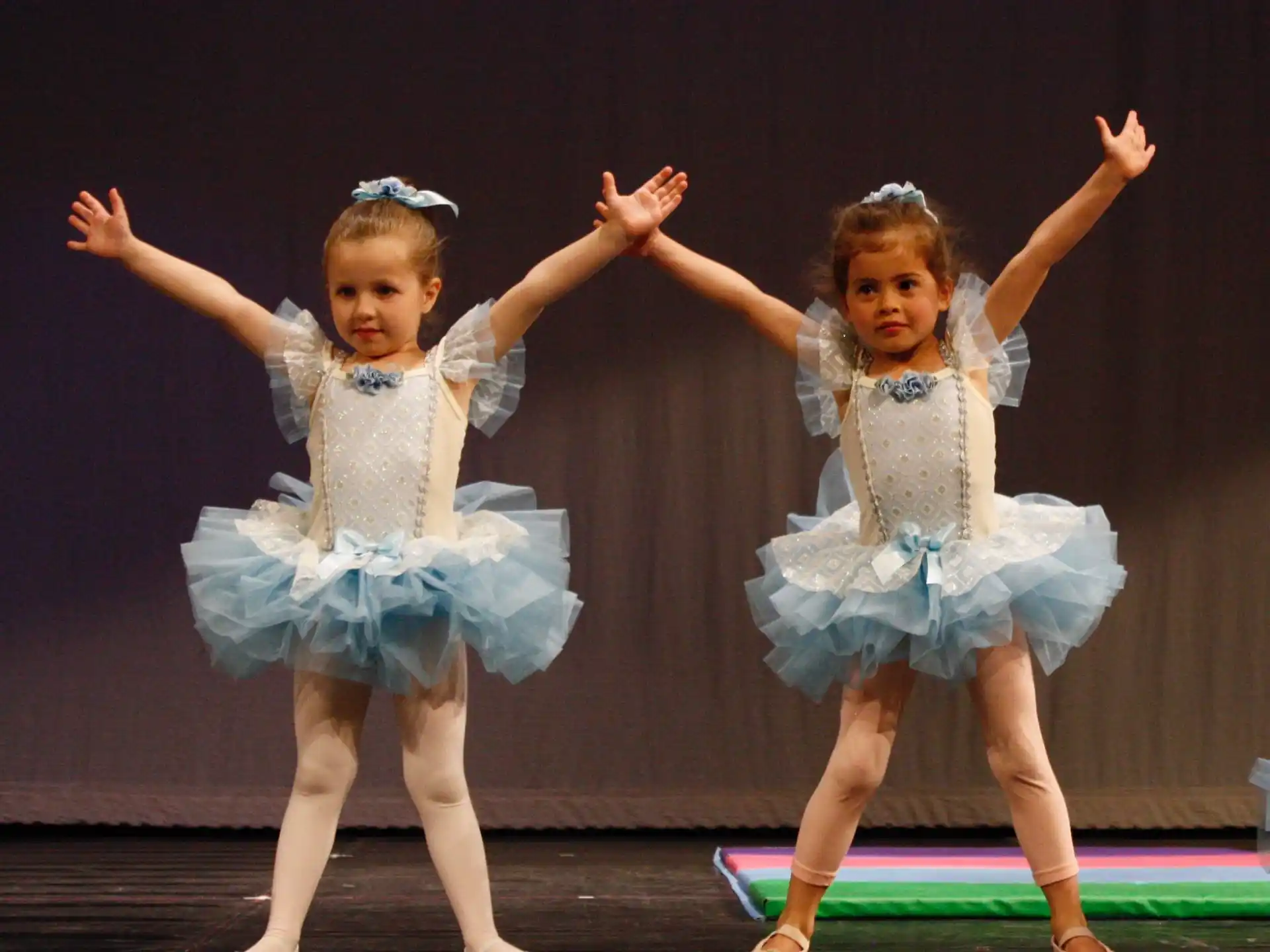 a couple of girls in dresses dancing