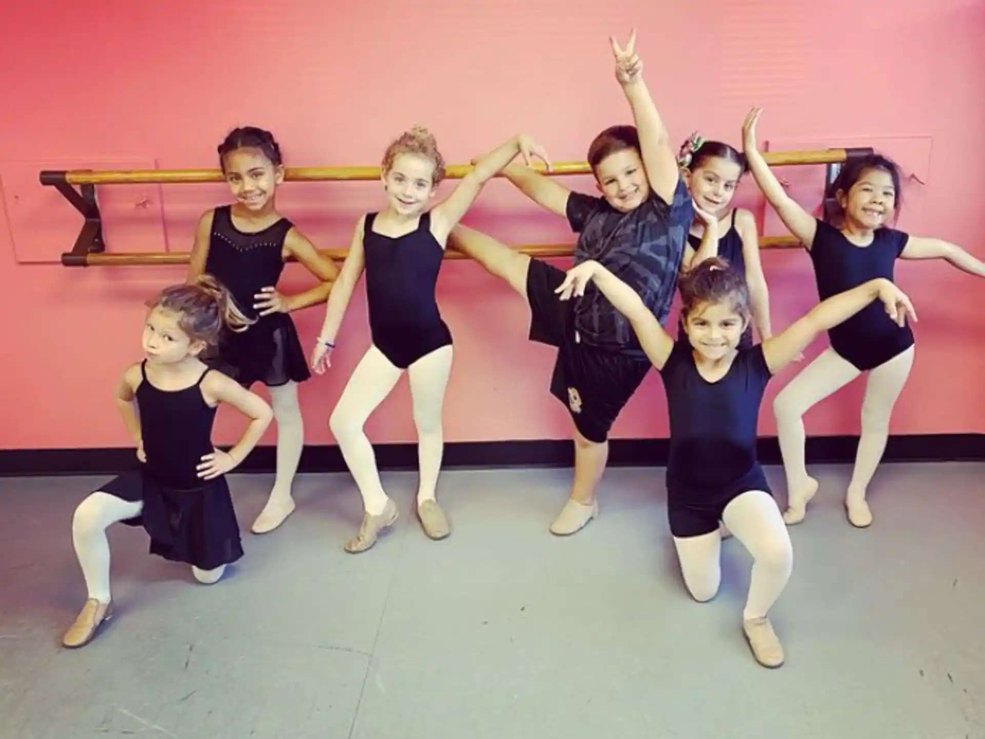 a group of girls in black and white dancing on a stage