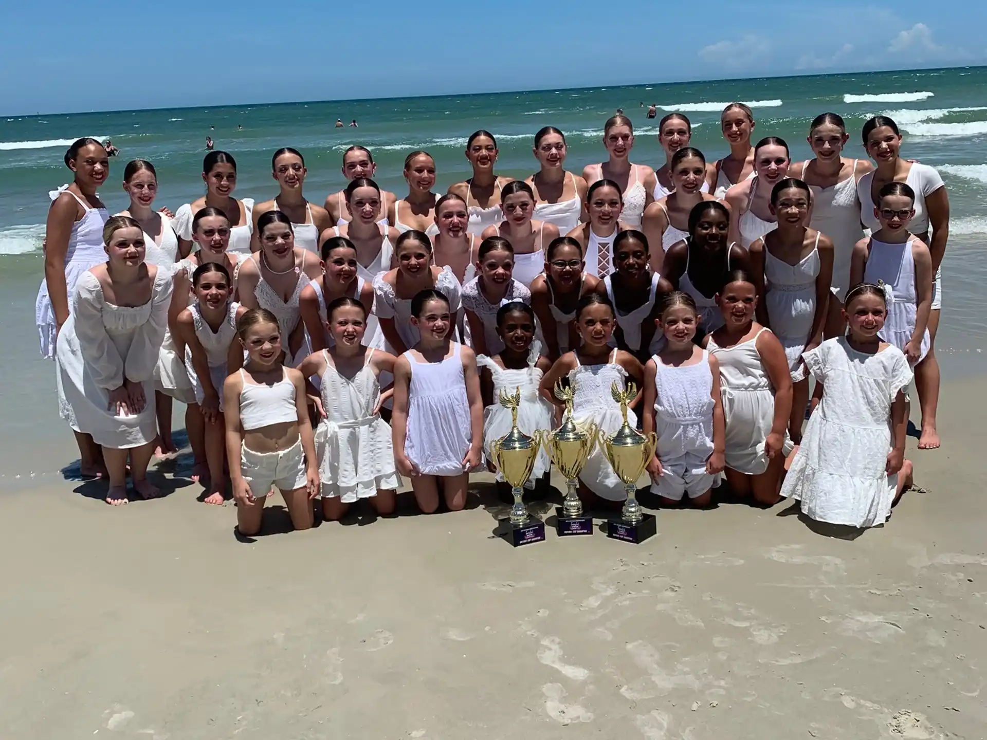 a group of people posing for a photo on a beach