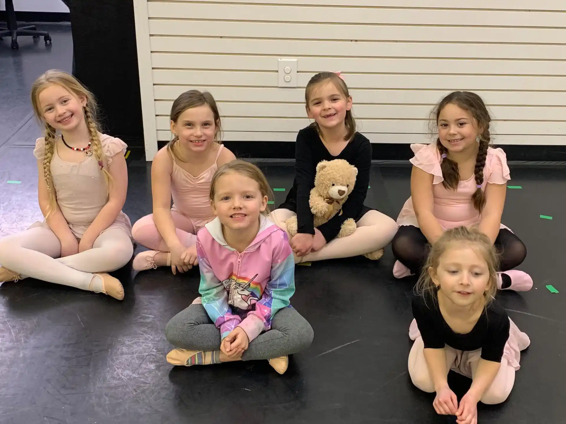 a group of girls sitting on mats