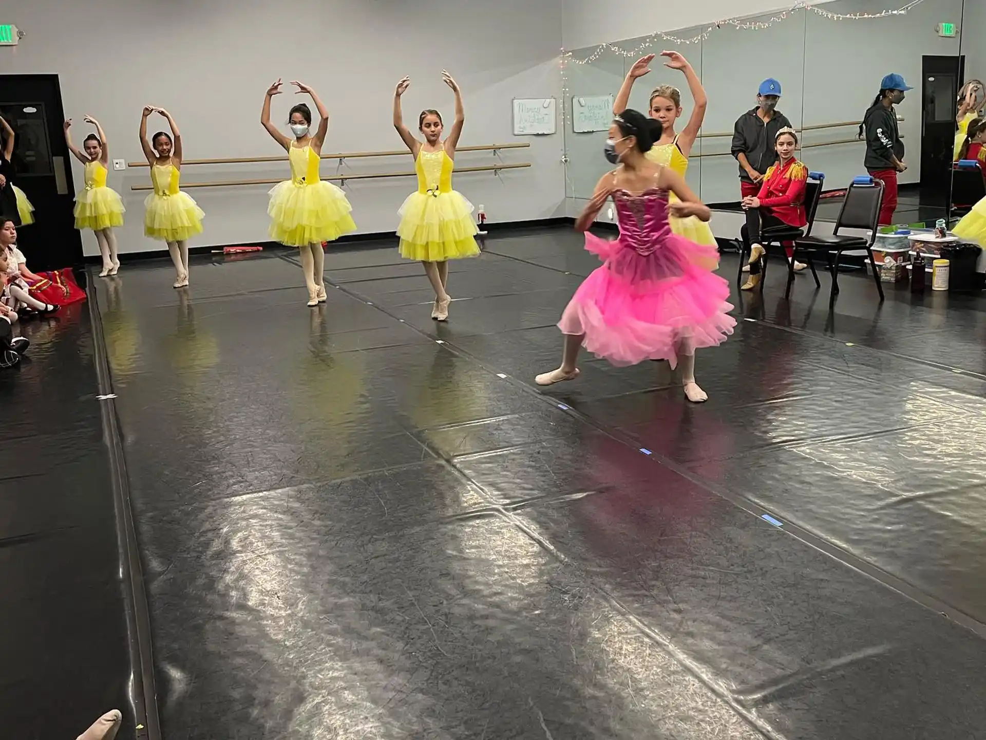 a group of girls dancing in a room with other people